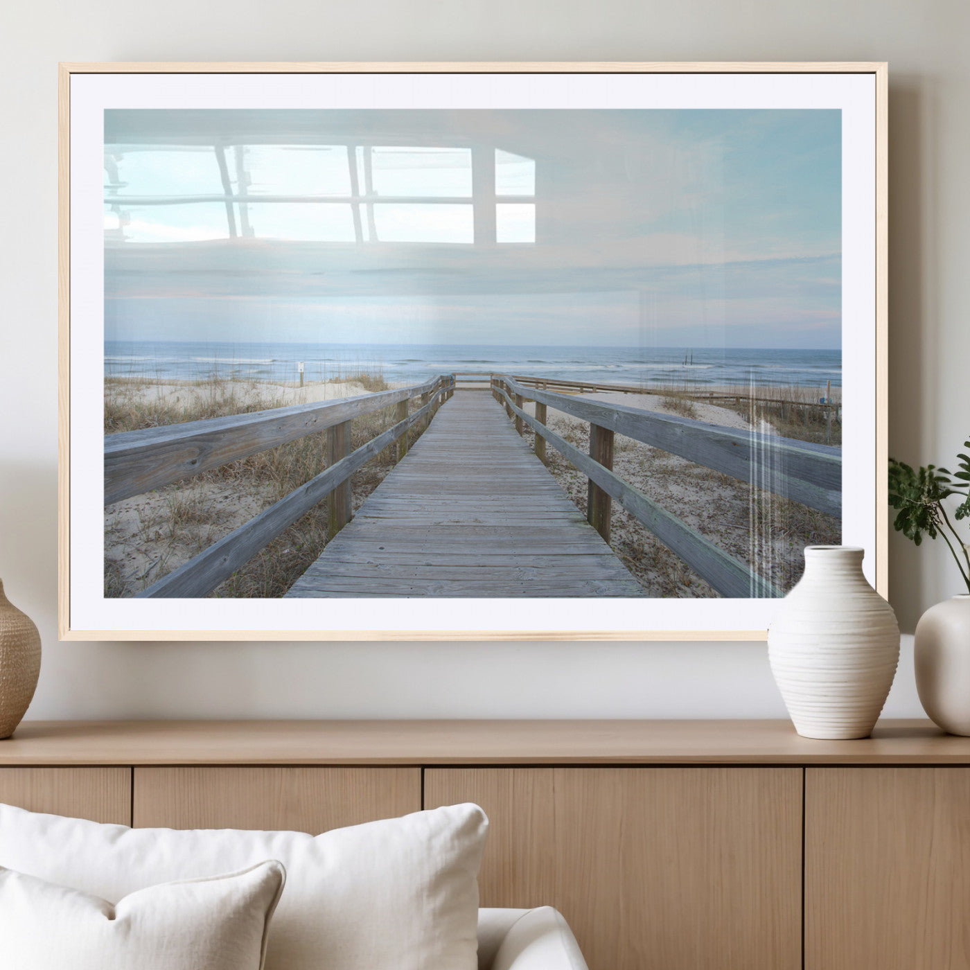 Wooden boardwalk leading to a peaceful beach with gentle ocean waves under a soft pastel sky, perfect for coastal and nautical home decor.
