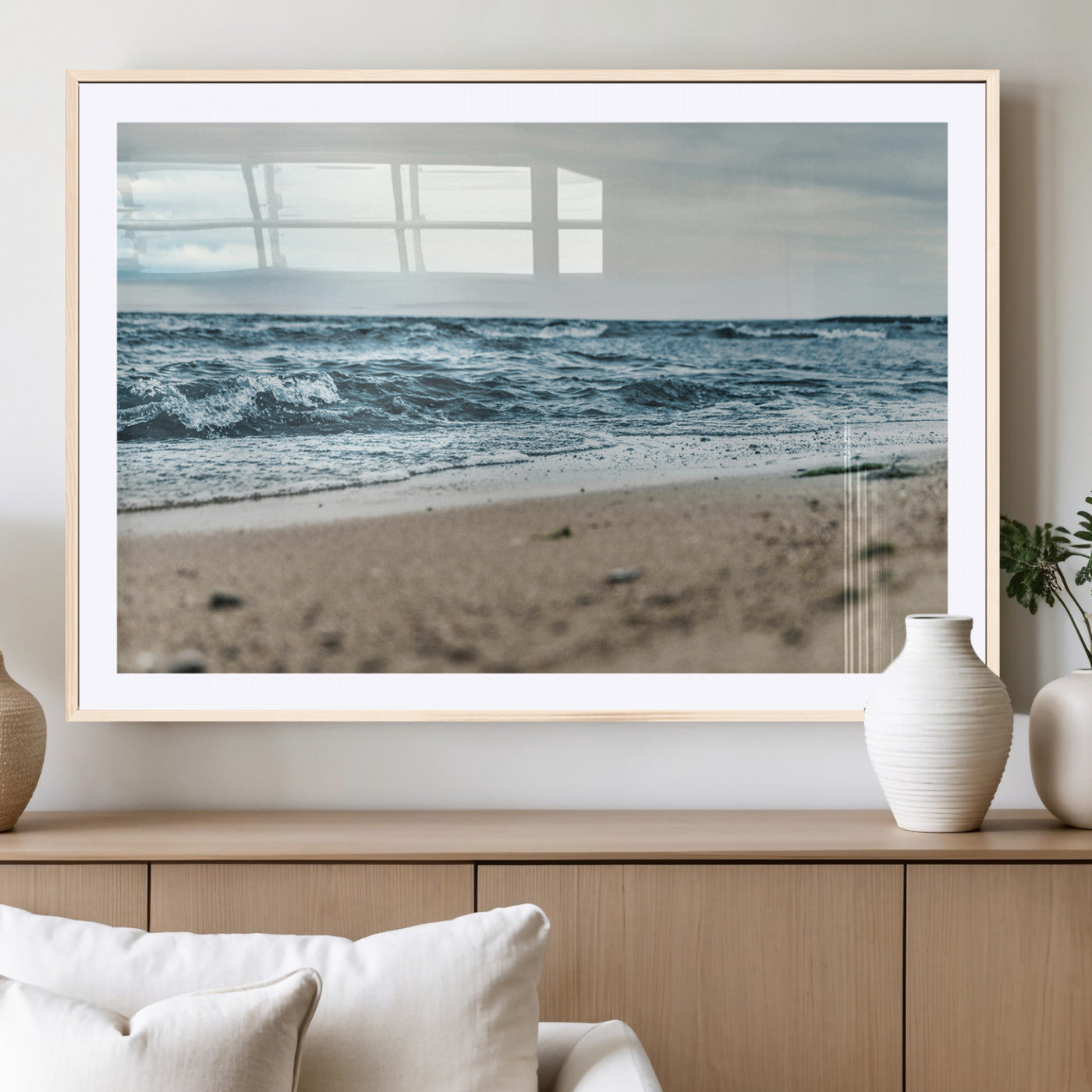 A moody ocean scene with gentle waves washing onto a sandy beach under a cloudy sky, creating a peaceful and coastal atmosphere.