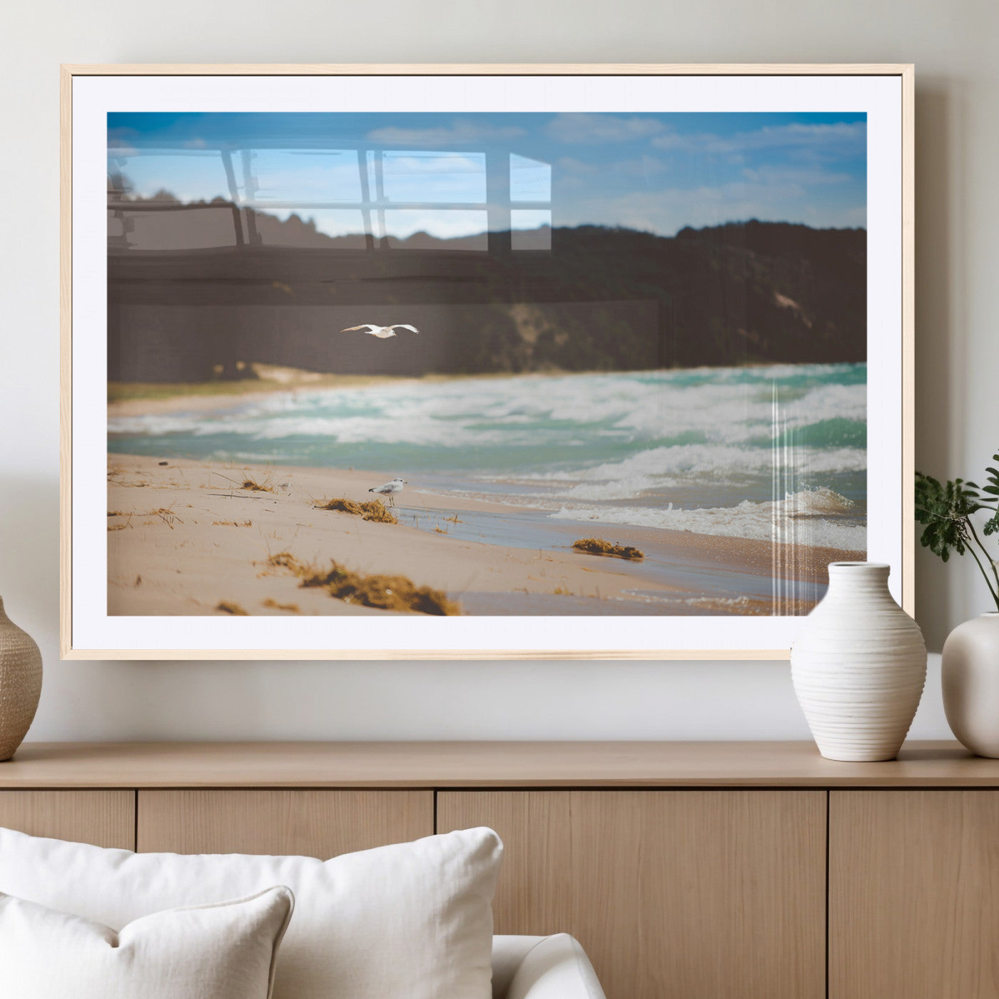 Serene beach scene with gentle ocean waves, sandy shore, and a seagull flying under a blue sky, perfect for coastal and nature-inspired decor.
