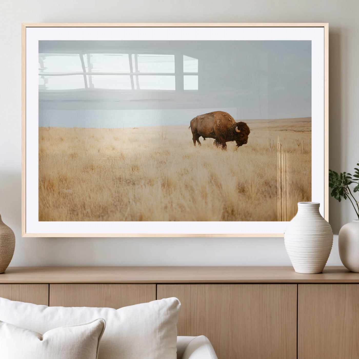 A lone bison standing in a vast golden grassland under a soft blue sky, evoking a rustic and Western aesthetic, ideal for farmhouse decor.