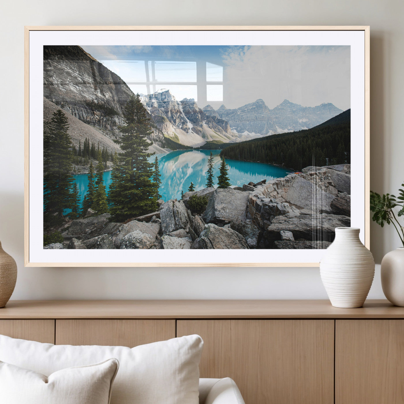 Stunning view of Moraine Lake with turquoise waters reflecting snow-capped mountains and evergreen trees, creating a peaceful alpine decor.