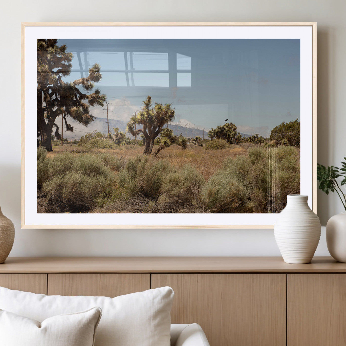 Scenic desert landscape with Joshua trees, dry grass, and distant mountains under a clear blue sky, perfect for southwestern and rustic decor.