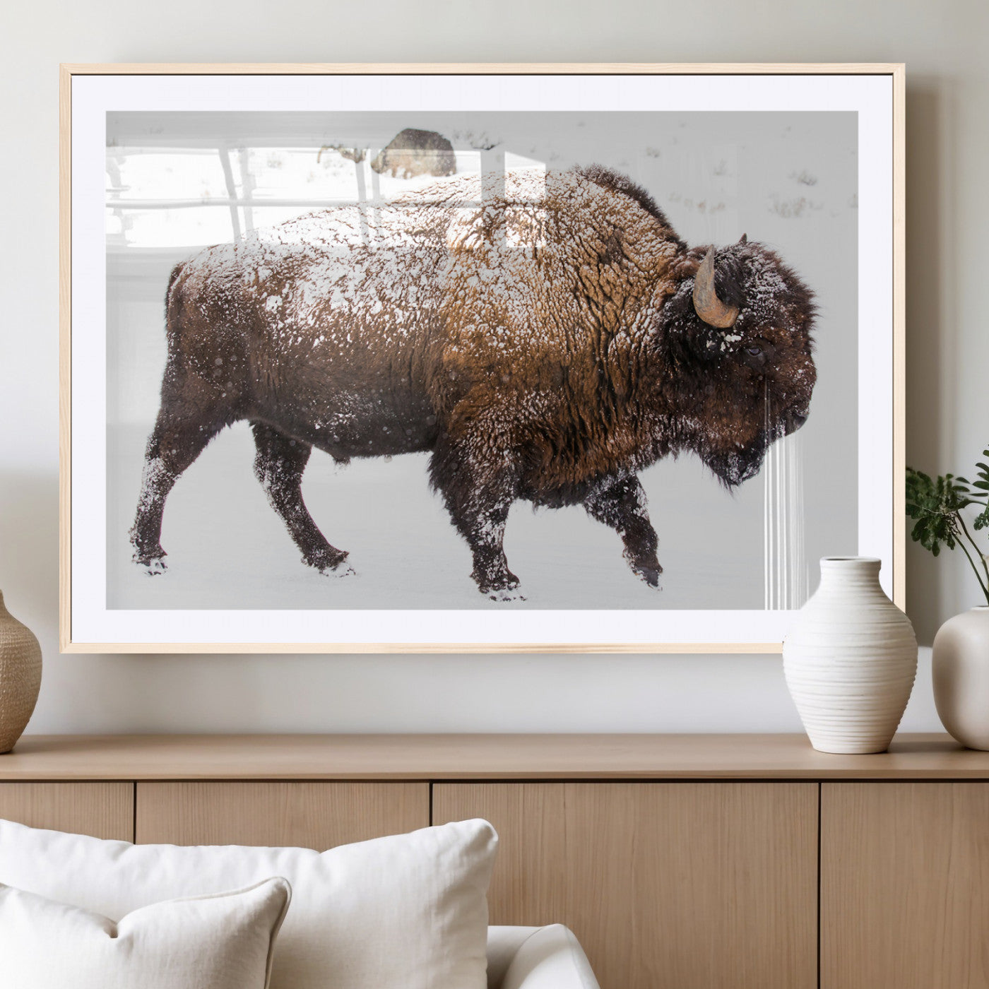 Side profile of a powerful bison walking through deep snow, with frost-covered fur and a white winter background, perfect for rustic and western decor.