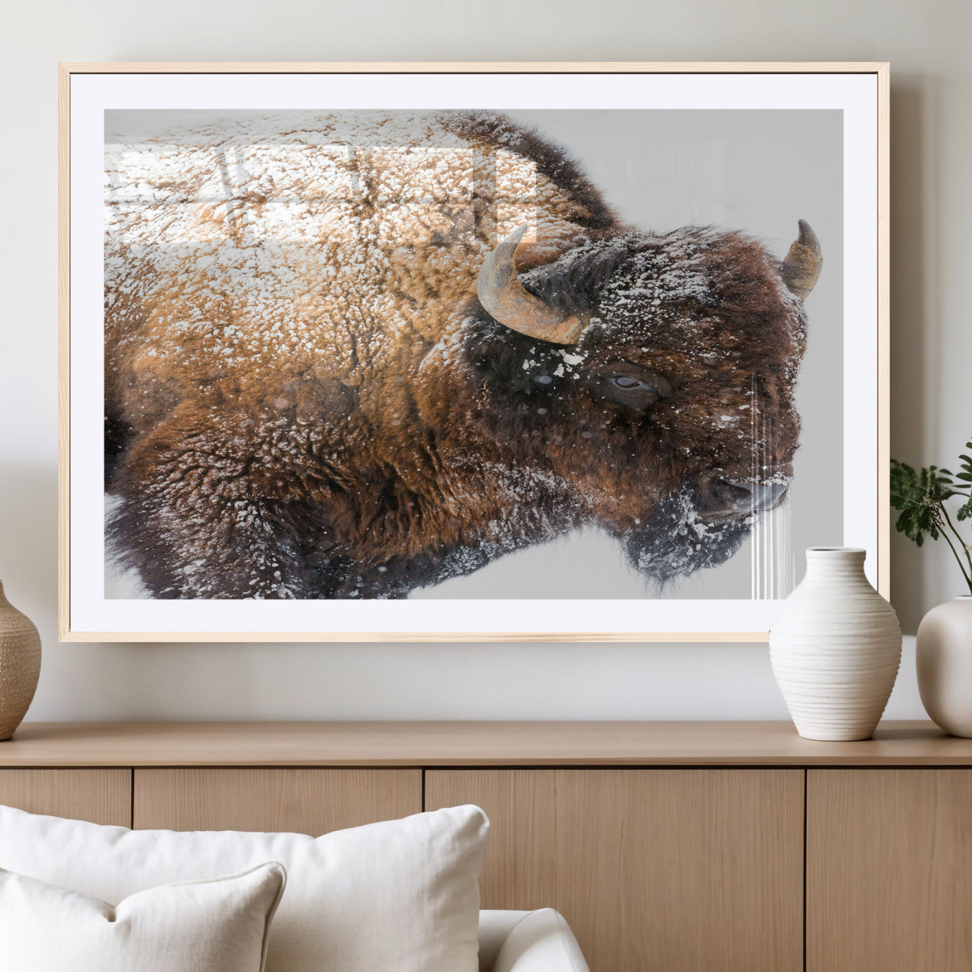 Close-up photograph of a bison covered in snow, highlighting its thick fur and powerful presence, set against a white winter backdrop, ideal for rustic decor.