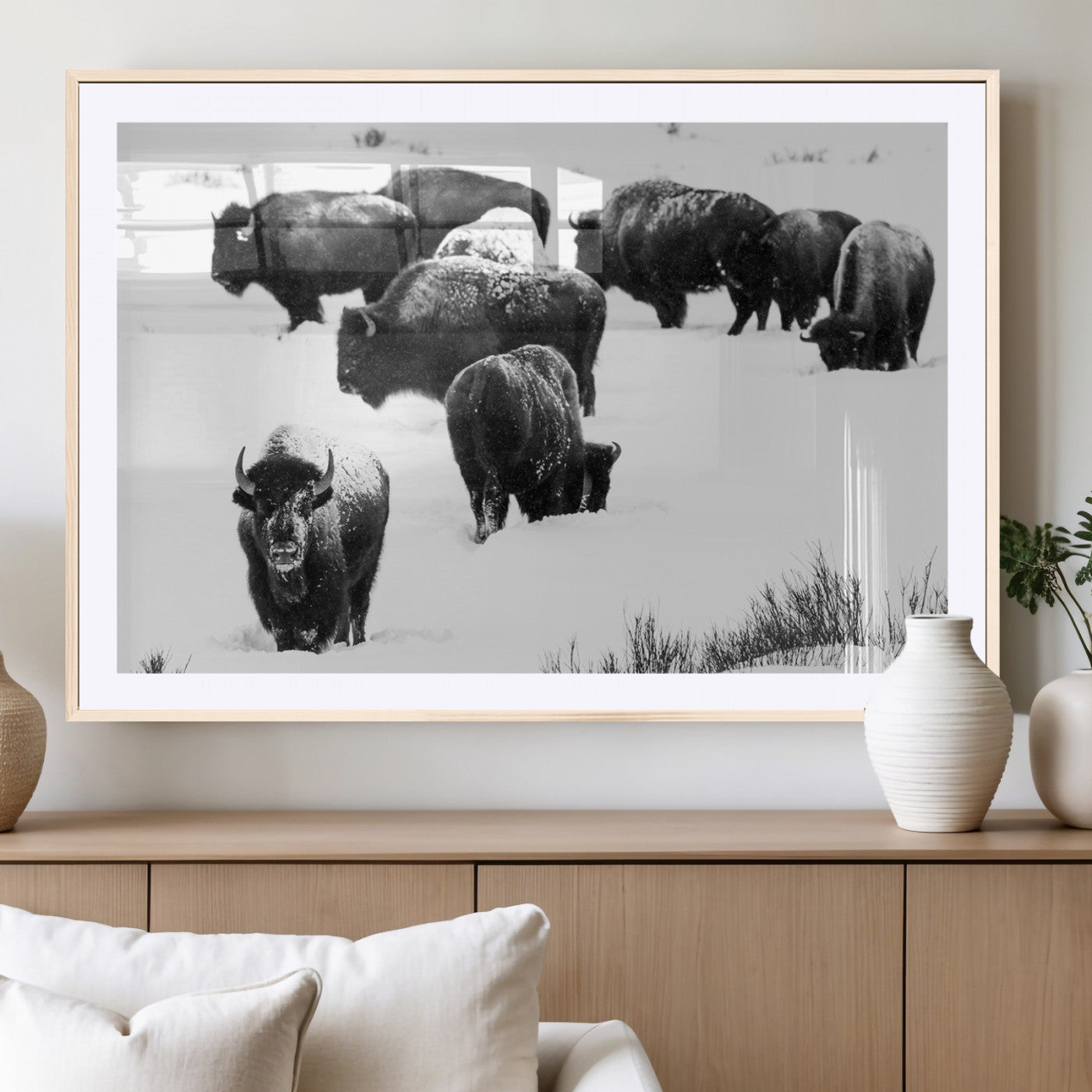 Black and white photograph of a bison herd in a snowy landscape, with snow-covered fur and a rugged wilderness setting, perfect for rustic lodge decor.