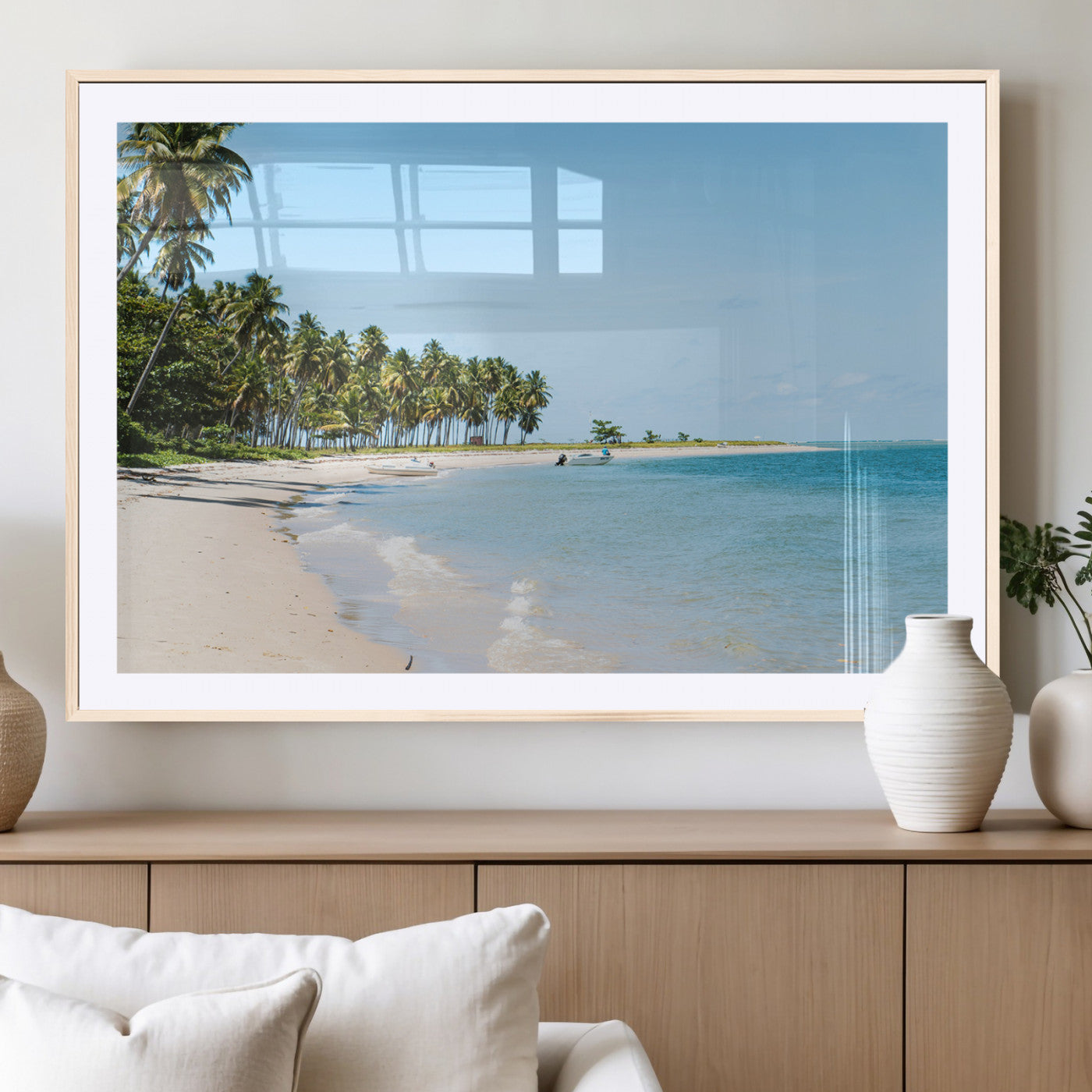 A serene tropical beach with clear blue water, soft sand, and lush palm trees under a bright sky, creating a peaceful island paradise atmosphere.