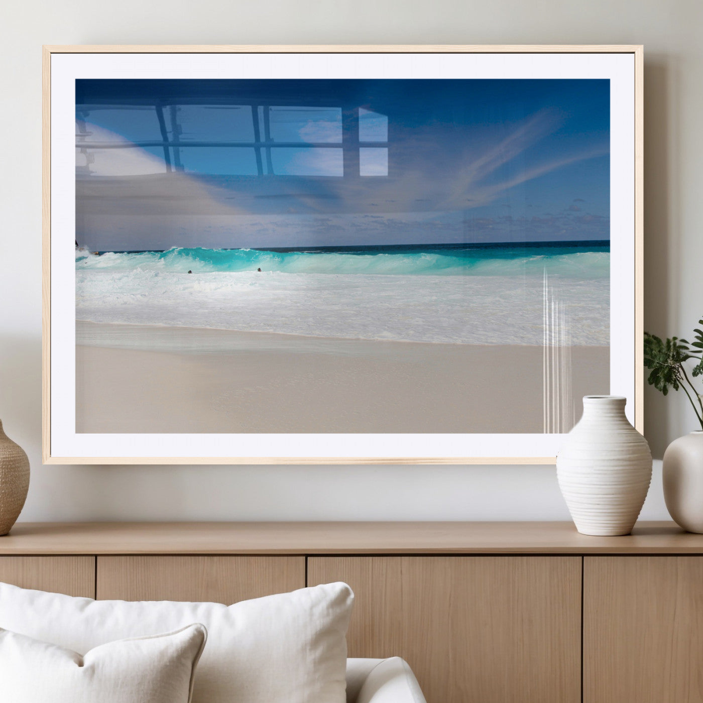Turquoise waves crash onto a pristine white sand beach under a vivid blue sky with wispy clouds, creating a peaceful and refreshing coastal scene.