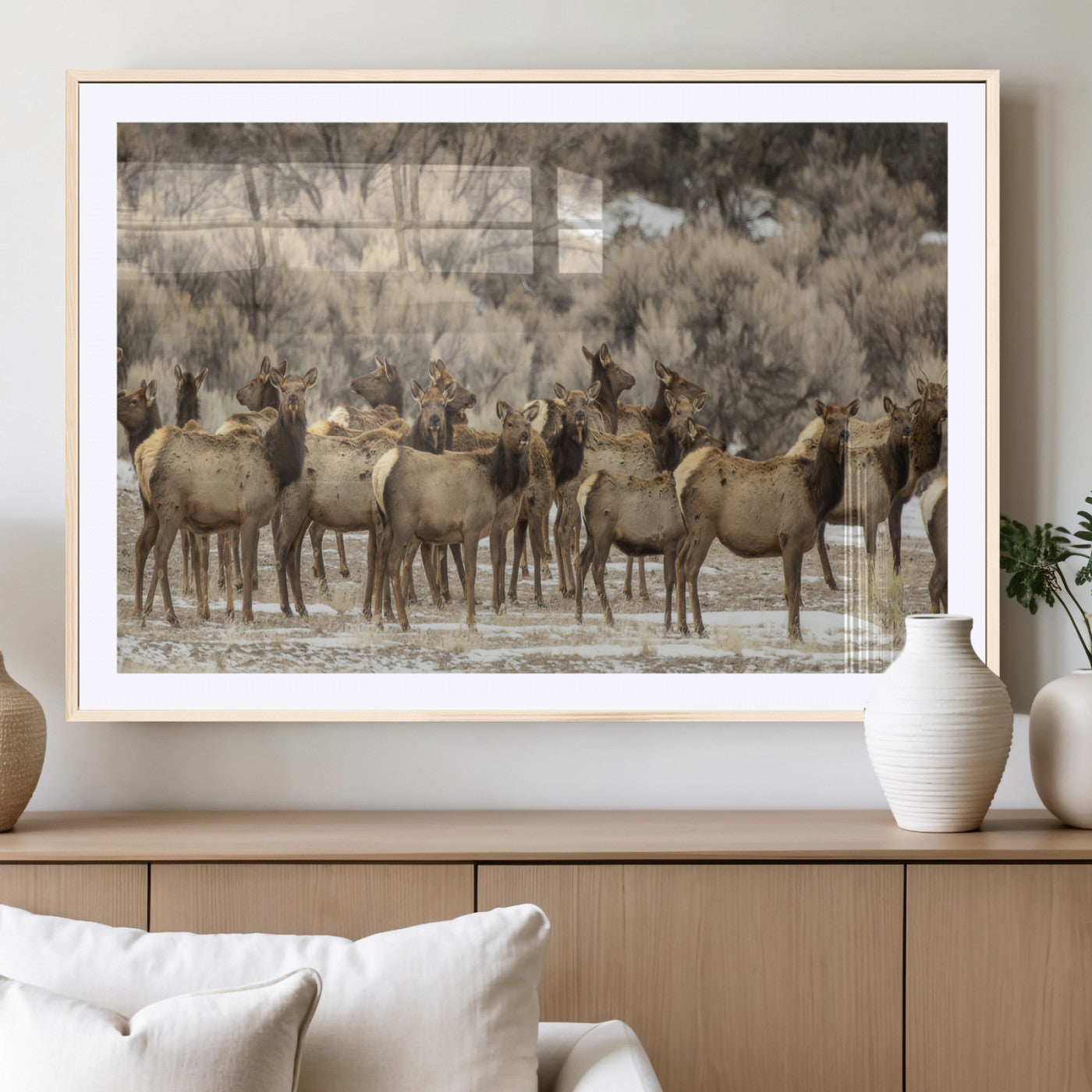 A stunning wall art canvas print featuring a large herd of elk standing together in a natural winter landscape with muted earthy tones and soft background foliage, perfect for rustic or nature-inspired home decor.