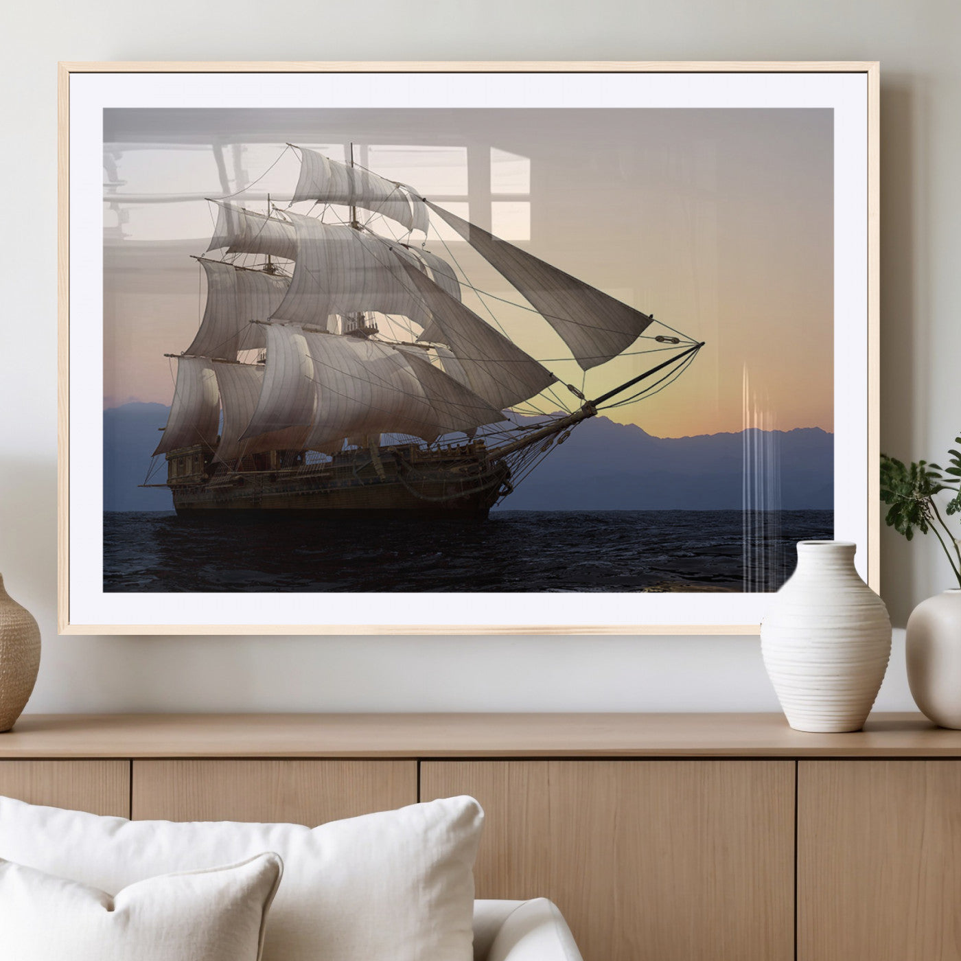 Majestic tall ship with full sails gliding across the ocean at sunset, with mountain silhouettes in the background – Wall Art Canvas Print.