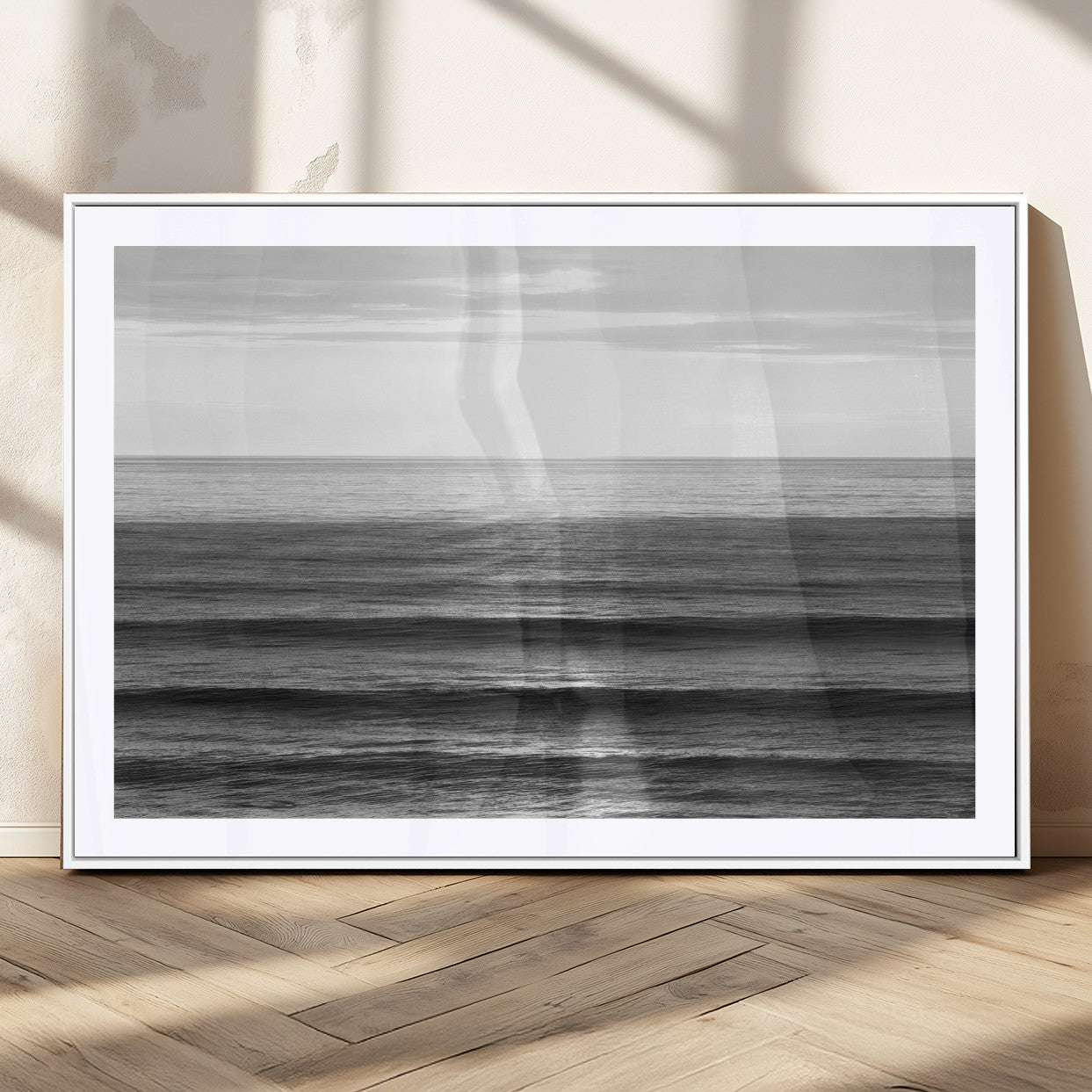 Minimalist black and white ocean view with layered waves reflecting sunlight, evoking a sense of calm and coastal serenity.