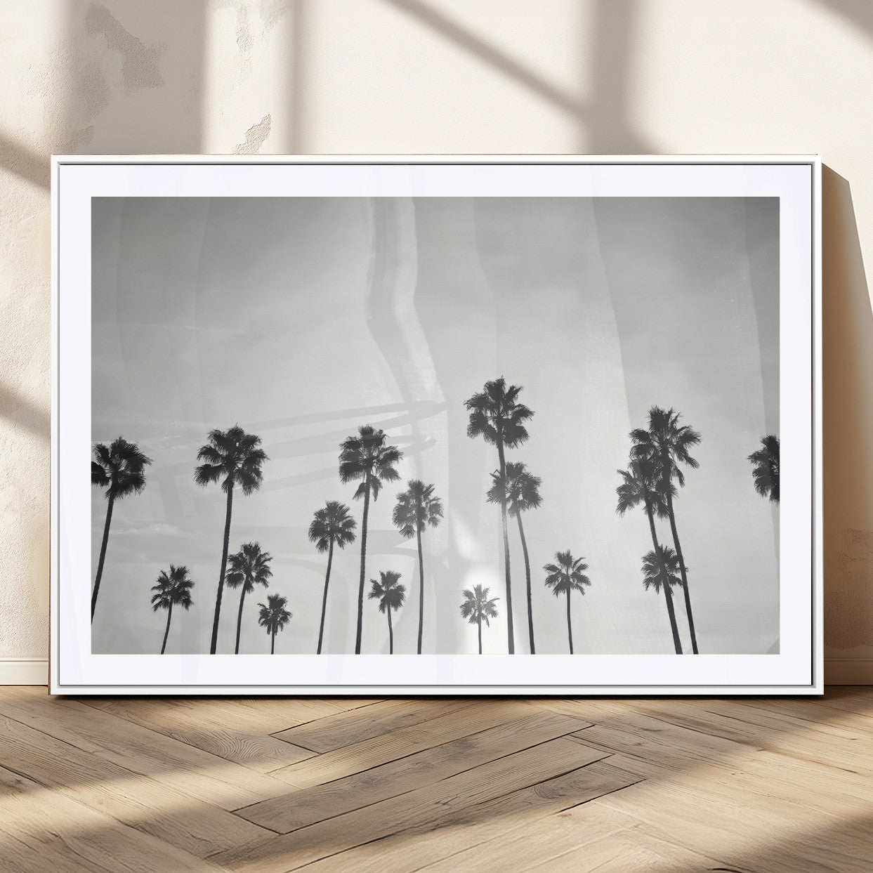 A black and white minimalist scene featuring tall palm trees silhouetted against a bright sky, creating a dreamy and timeless tropical aesthetic.