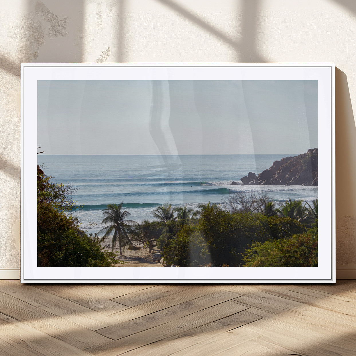 View of calm ocean waves with palm trees and a tropical coastline, ideal for coastal boho or beach-themed wall decor.