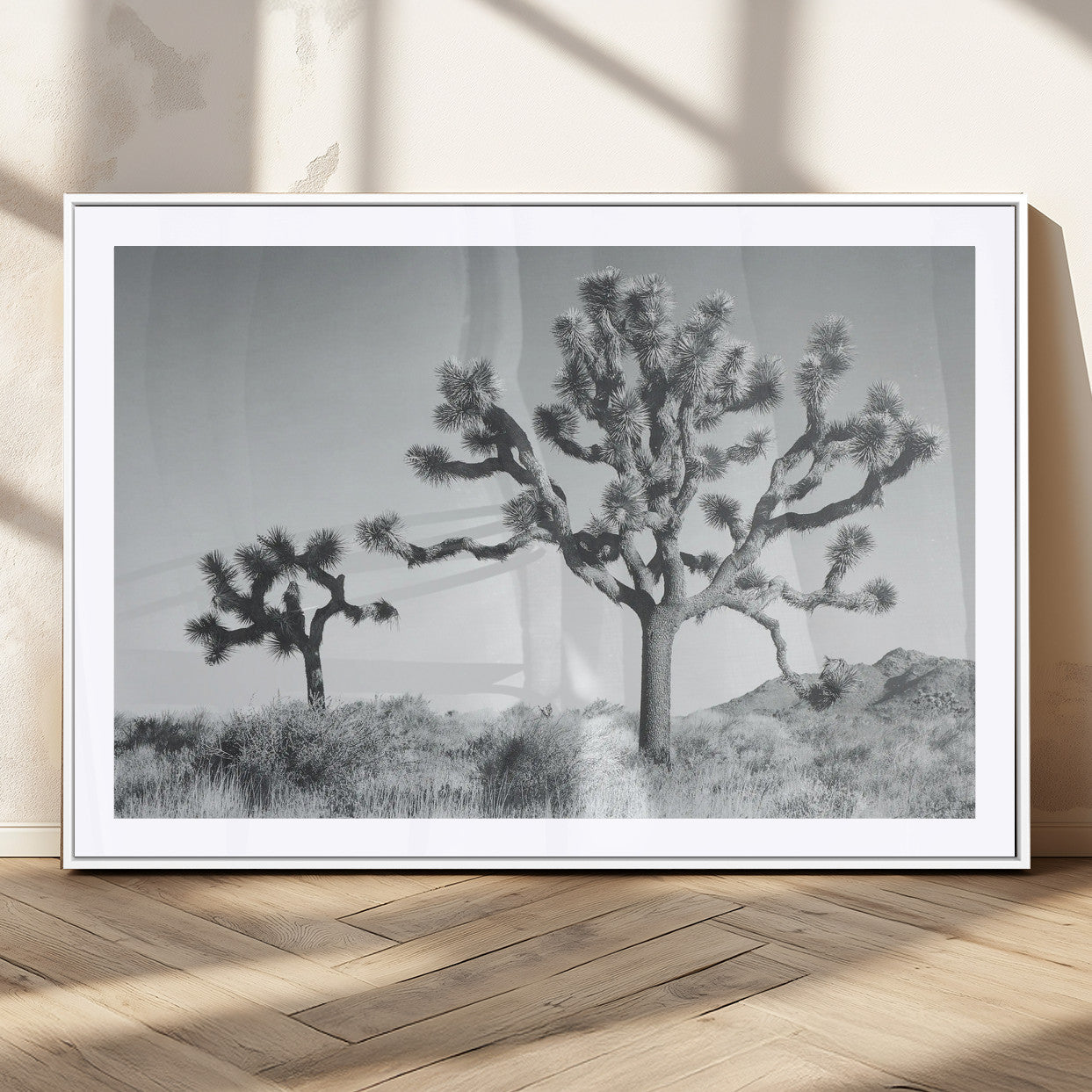 Two Joshua trees in a black and white desert landscape with distant hills, ideal for boho or rustic interior wall styling.