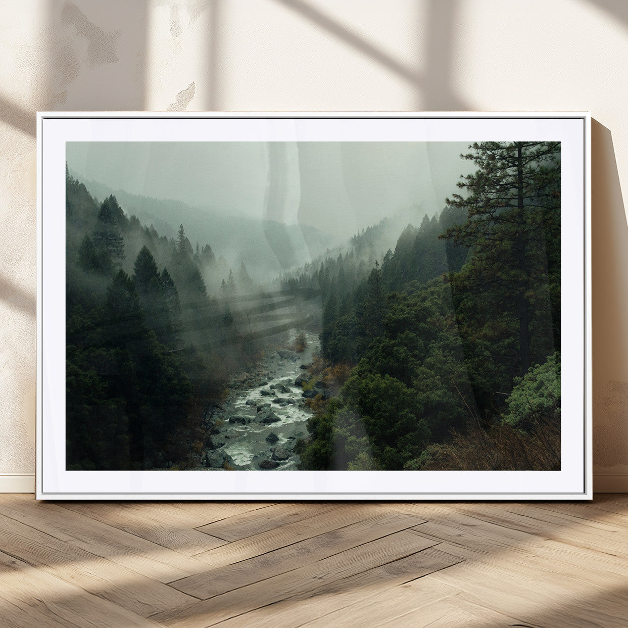 Misty forest with a winding river flowing through lush green mountains, creating a tranquil and moody wilderness landscape.