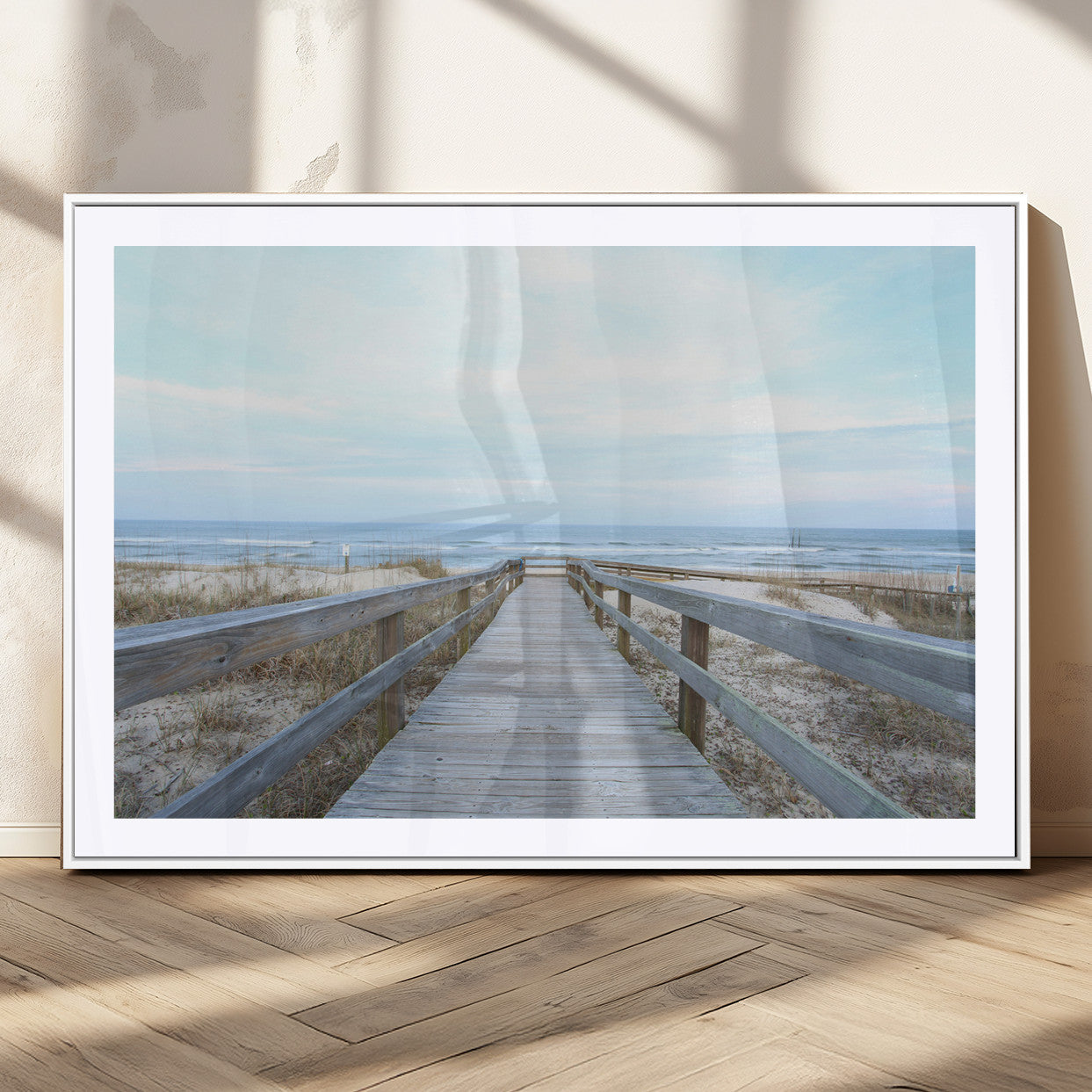 Wooden boardwalk leading to a peaceful beach with gentle ocean waves under a soft pastel sky, perfect for coastal and nautical home decor.