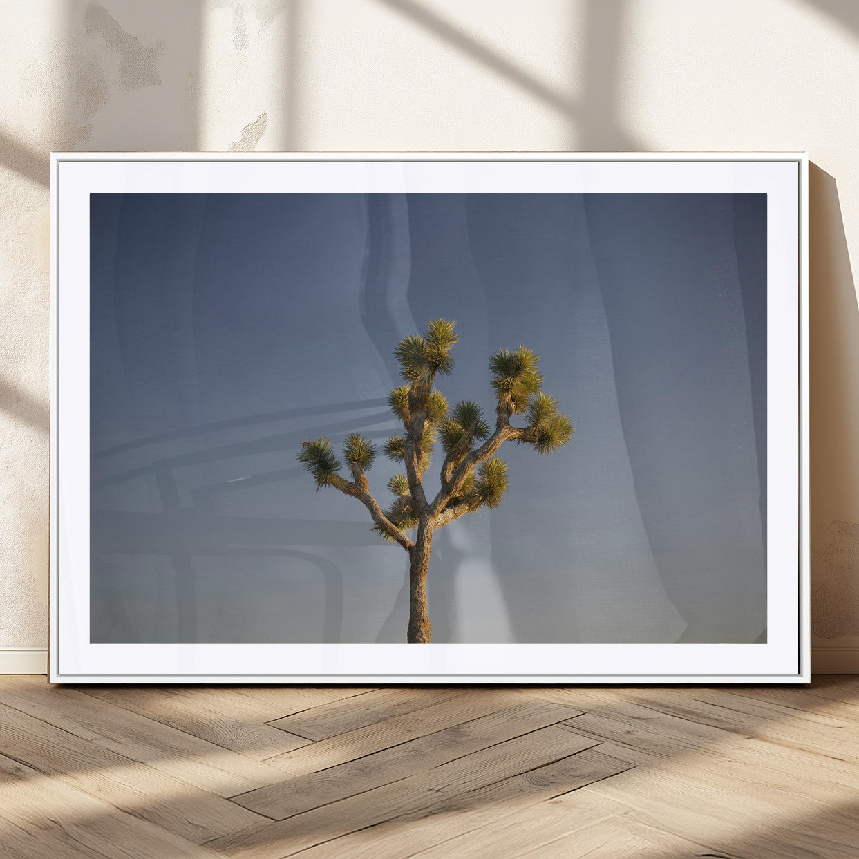 A lone Joshua Tree standing against a deep blue sky, capturing the serene and rugged beauty of the Southwestern desert landscape.