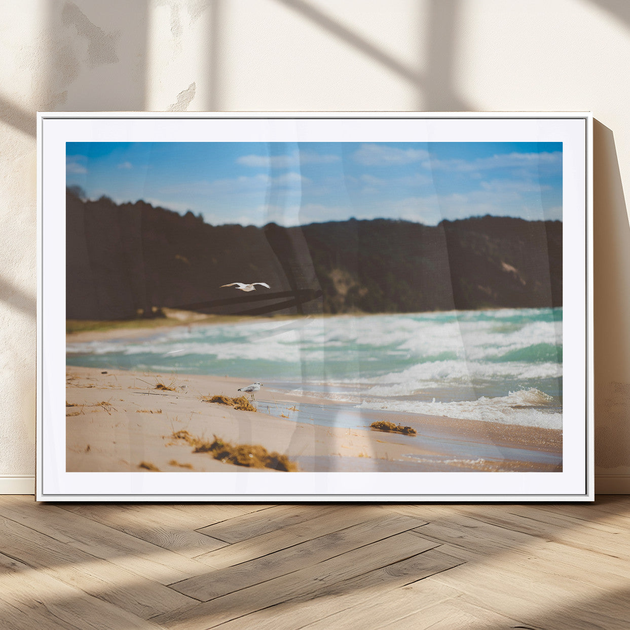 Serene beach scene with gentle ocean waves, sandy shore, and a seagull flying under a blue sky, perfect for coastal and nature-inspired decor.