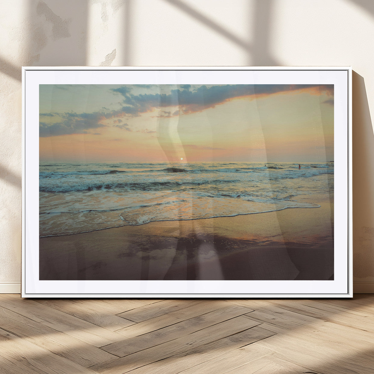 Warm sunset over gentle ocean waves with pastel sky and reflections on wet sand, creating a calm and soothing beach ambiance.