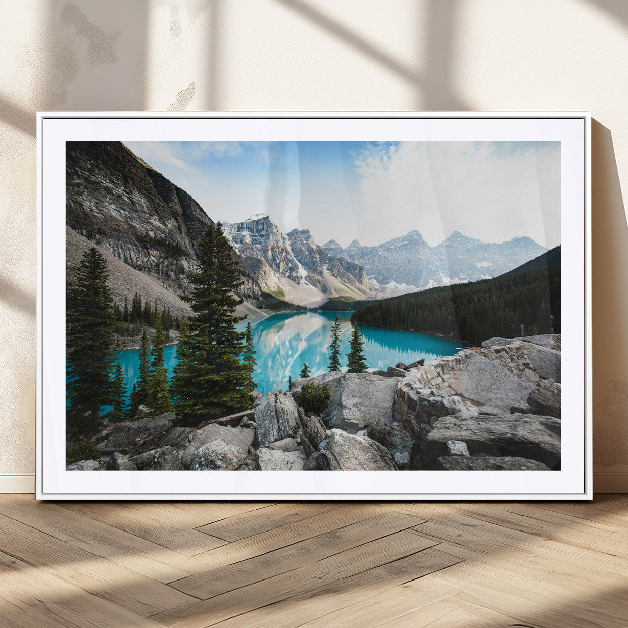 Stunning view of Moraine Lake with turquoise waters reflecting snow-capped mountains and evergreen trees, creating a peaceful alpine decor.