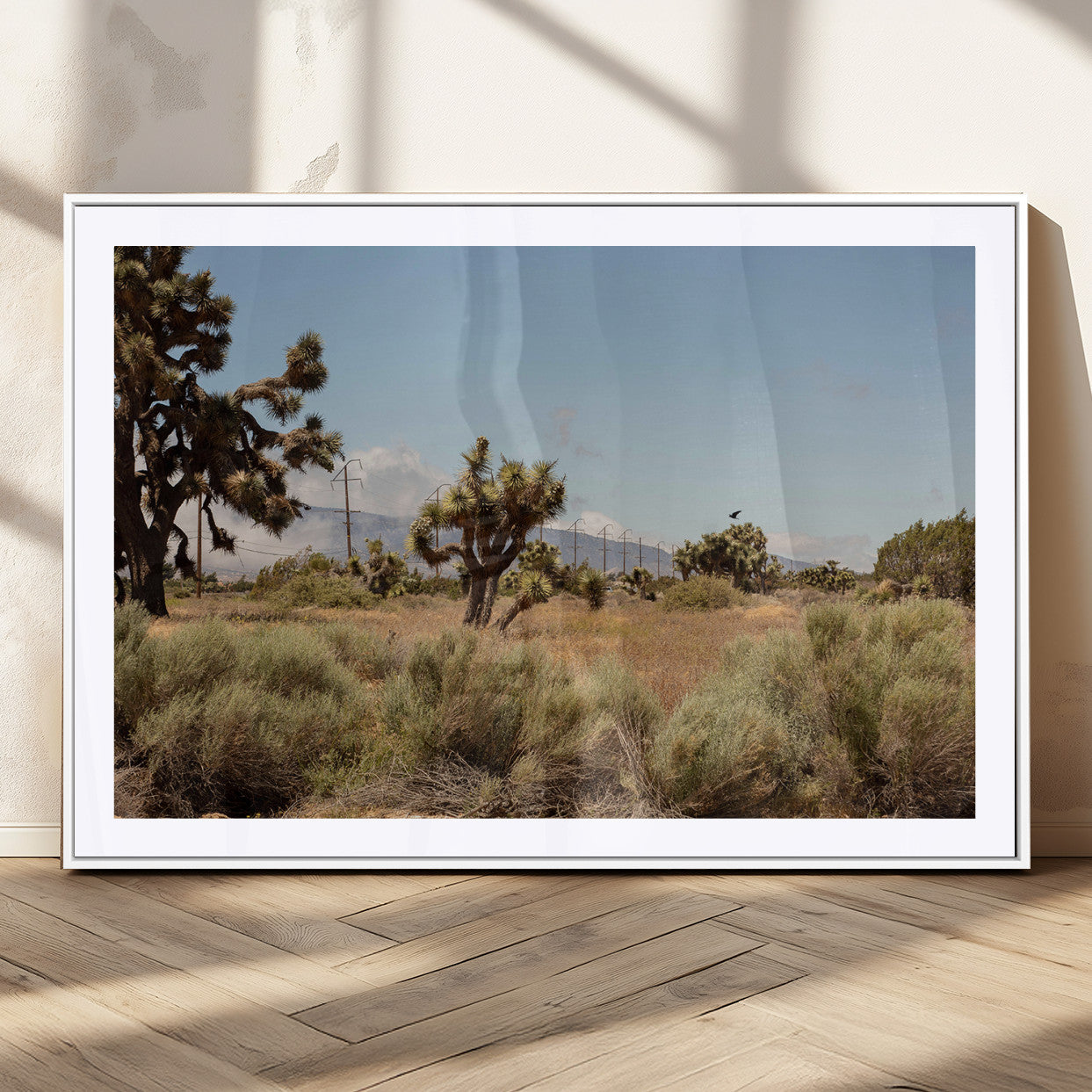 Scenic desert landscape with Joshua trees, dry grass, and distant mountains under a clear blue sky, perfect for southwestern and rustic decor.