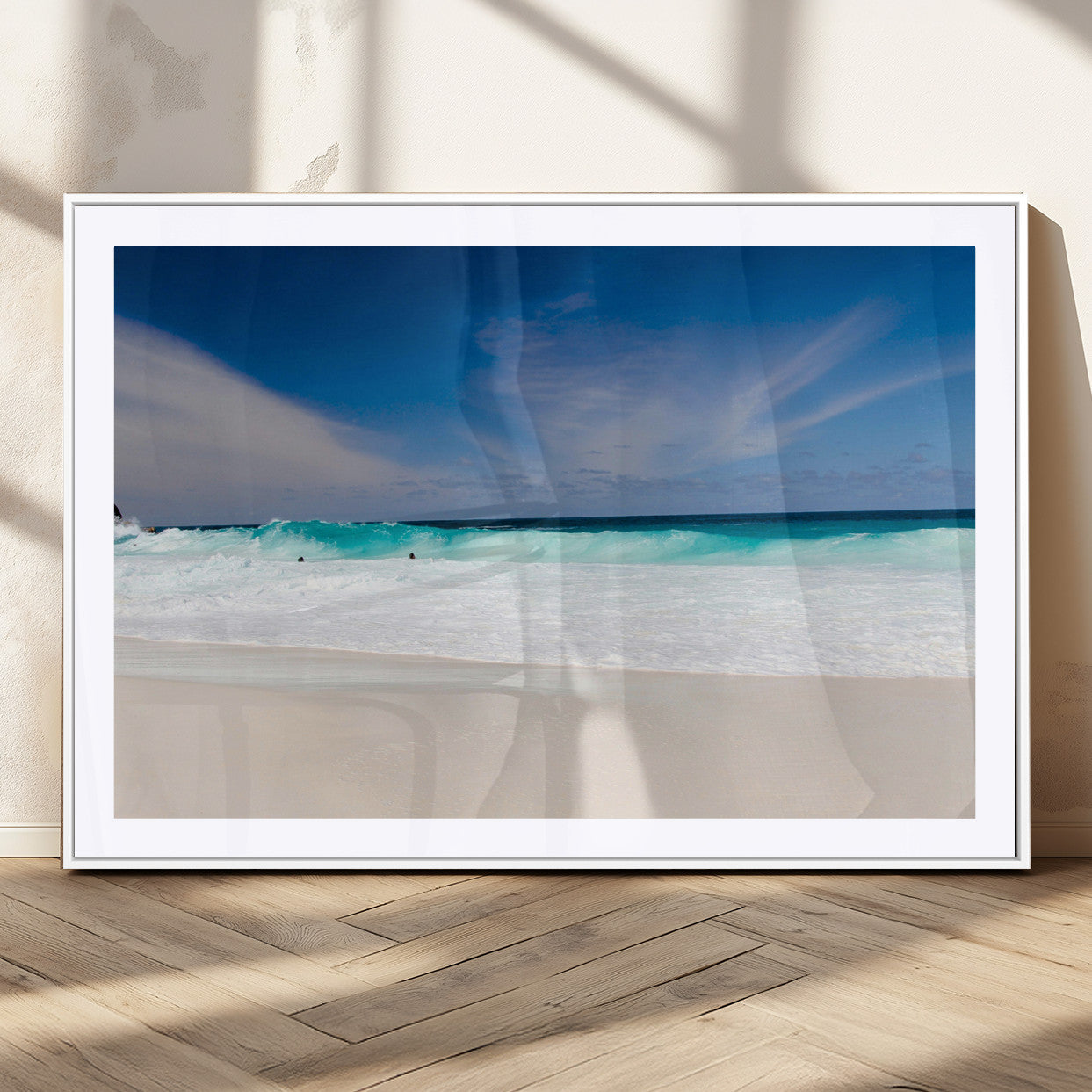 Turquoise waves crash onto a pristine white sand beach under a vivid blue sky with wispy clouds, creating a peaceful and refreshing coastal scene.