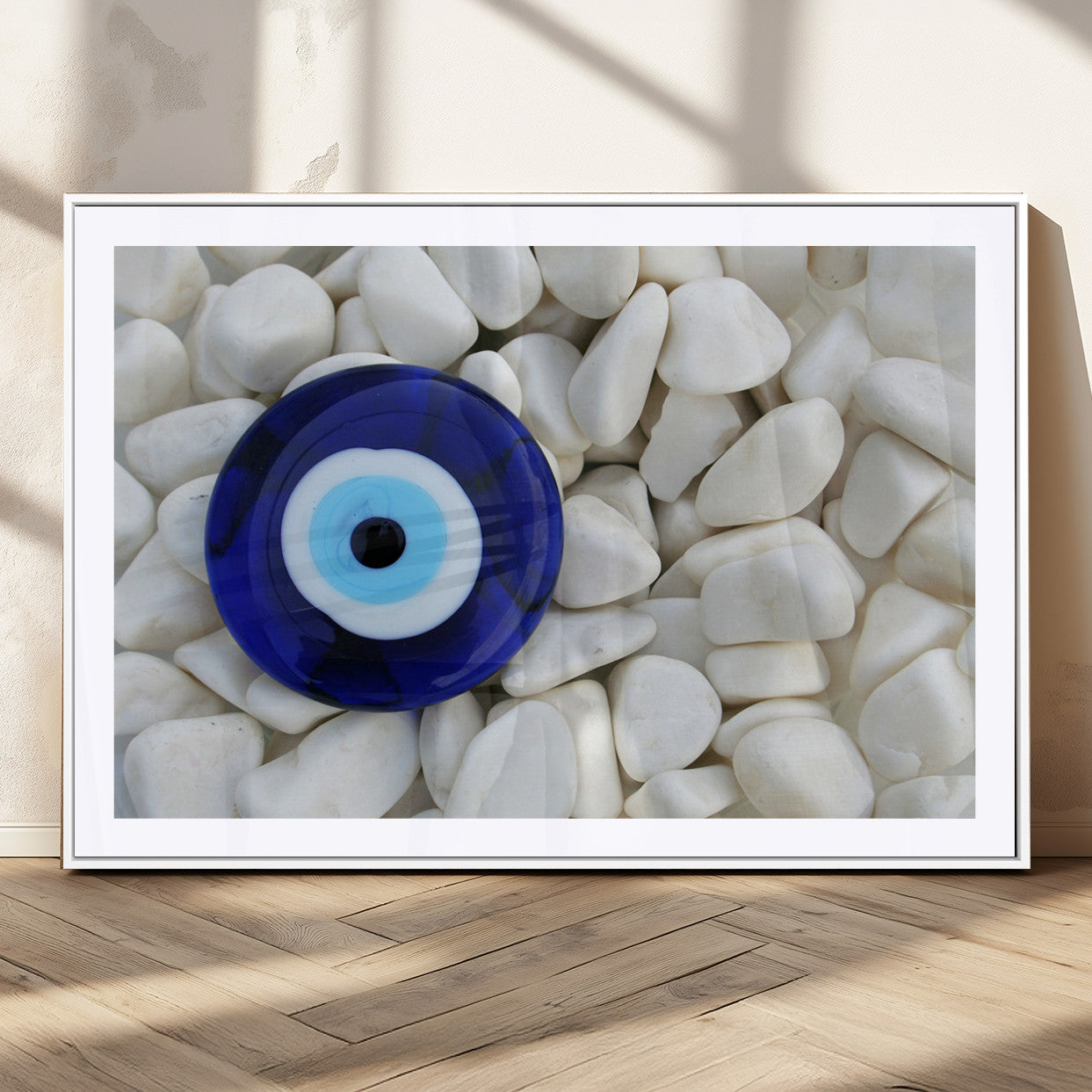 A close-up of a blue evil eye charm placed on white pebbles, symbolizing protection and good luck.