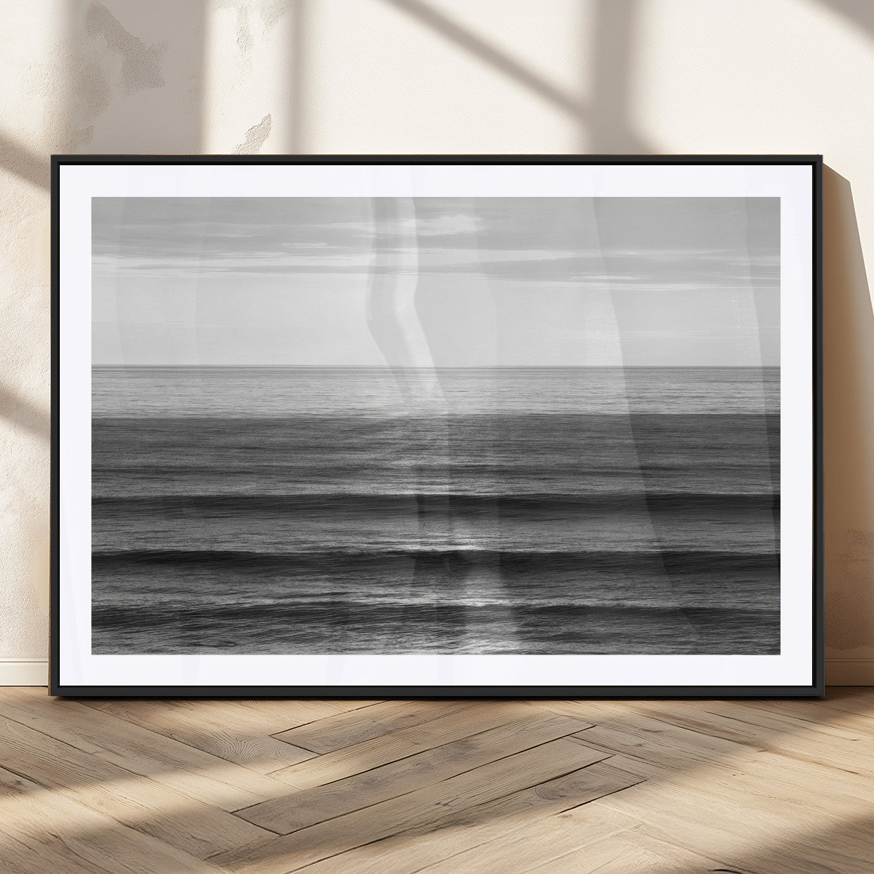 Minimalist black and white ocean view with layered waves reflecting sunlight, evoking a sense of calm and coastal serenity.