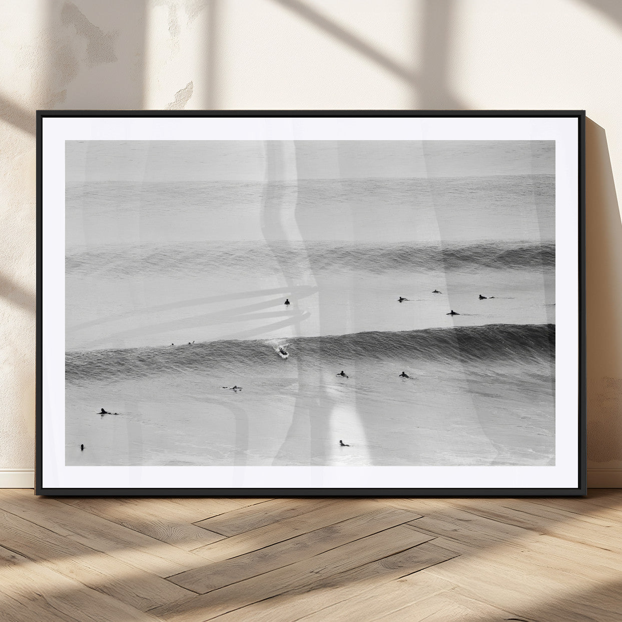 A monochrome photograph of swimmers gliding through gentle ocean waves, evoking a sense of calm and movement.