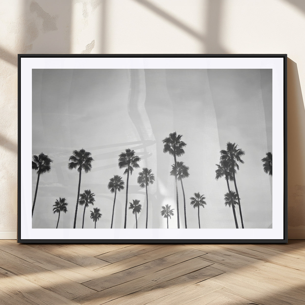 A black and white minimalist scene featuring tall palm trees silhouetted against a bright sky, creating a dreamy and timeless tropical aesthetic.