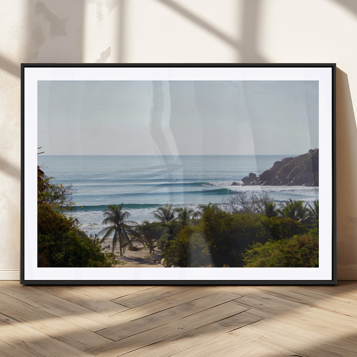 View of calm ocean waves with palm trees and a tropical coastline, ideal for coastal boho or beach-themed wall decor.