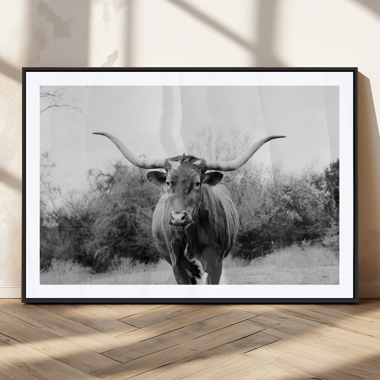 Black and white photo of a Longhorn cow facing camera, ideal for rustic, farmhouse, or western-themed home wall decor.