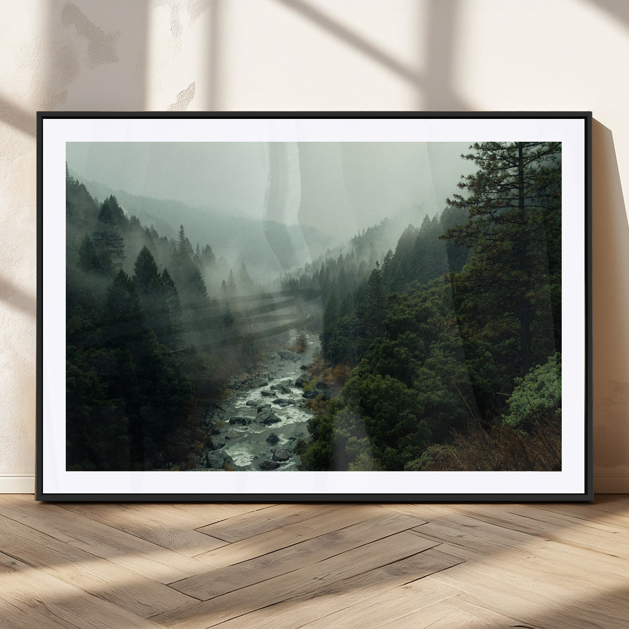 Misty forest with a winding river flowing through lush green mountains, creating a tranquil and moody wilderness landscape.