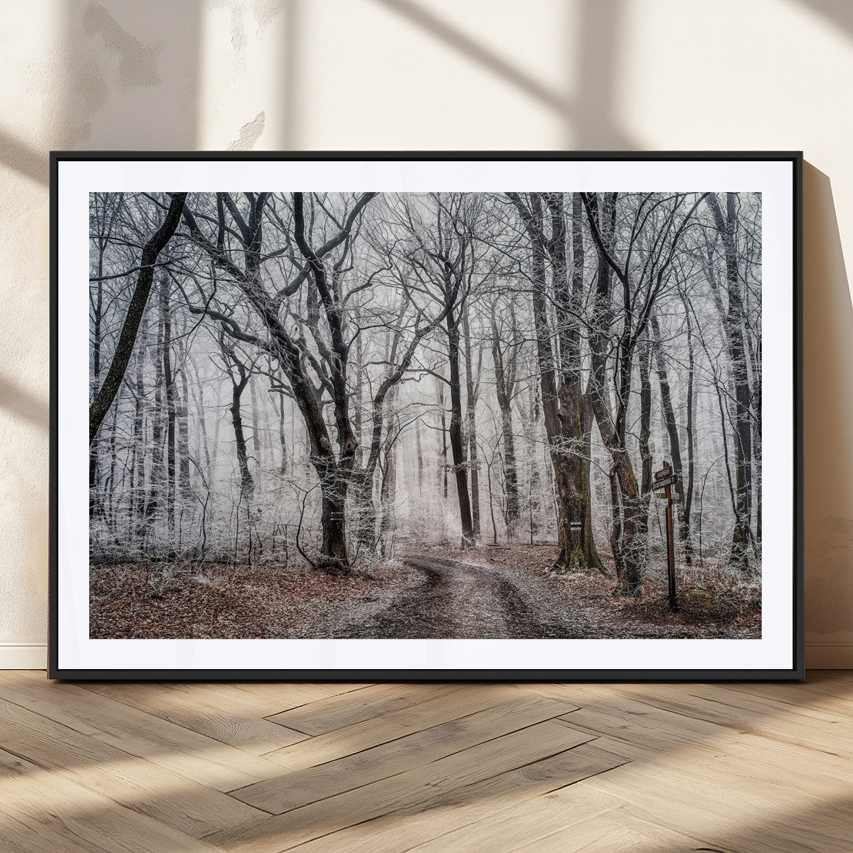 Snow-covered trees in a misty winter forest with a winding path, creating a serene and mysterious atmosphere, perfect for nature-inspired wall art.