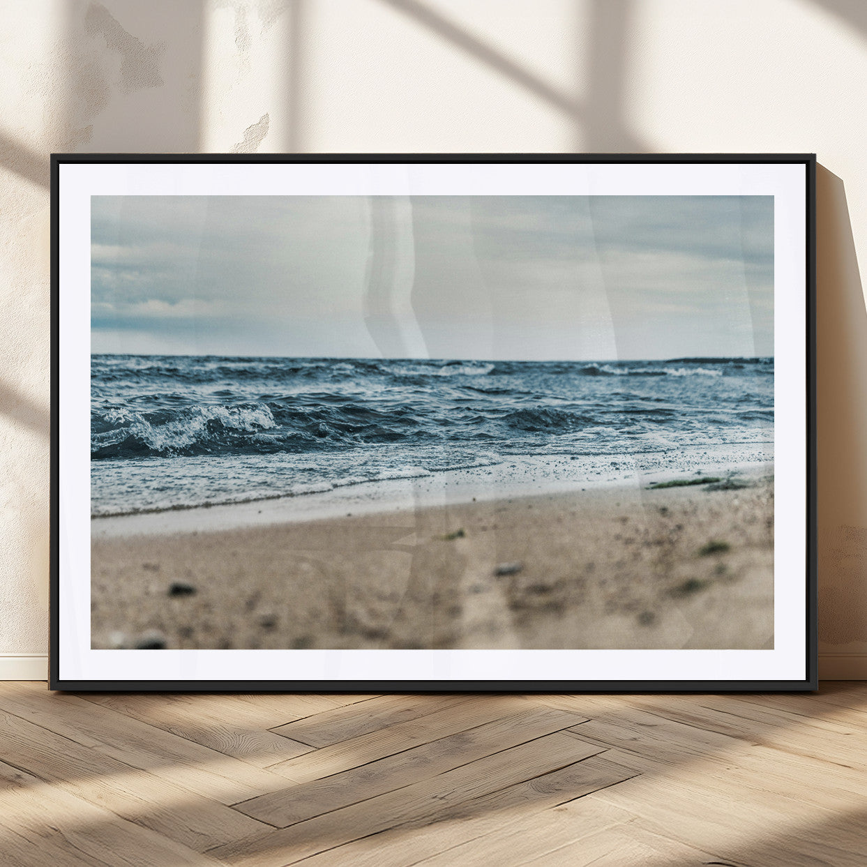 A moody ocean scene with gentle waves washing onto a sandy beach under a cloudy sky, creating a peaceful and coastal atmosphere.
