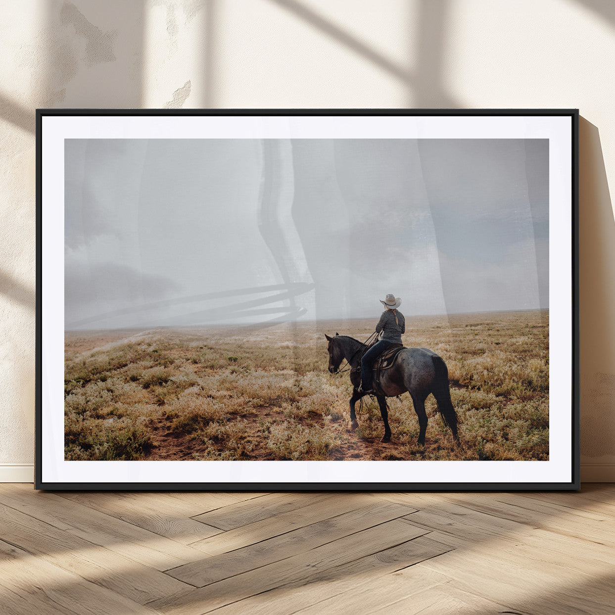 A lone cowboy riding horseback across an open prairie under a vast sky, capturing the rugged and timeless spirit of the Western frontier.