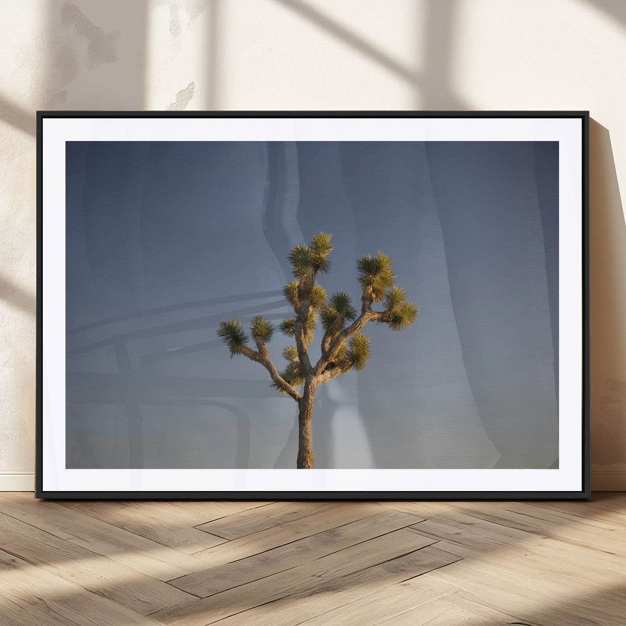 A lone Joshua Tree standing against a deep blue sky, capturing the serene and rugged beauty of the Southwestern desert landscape.