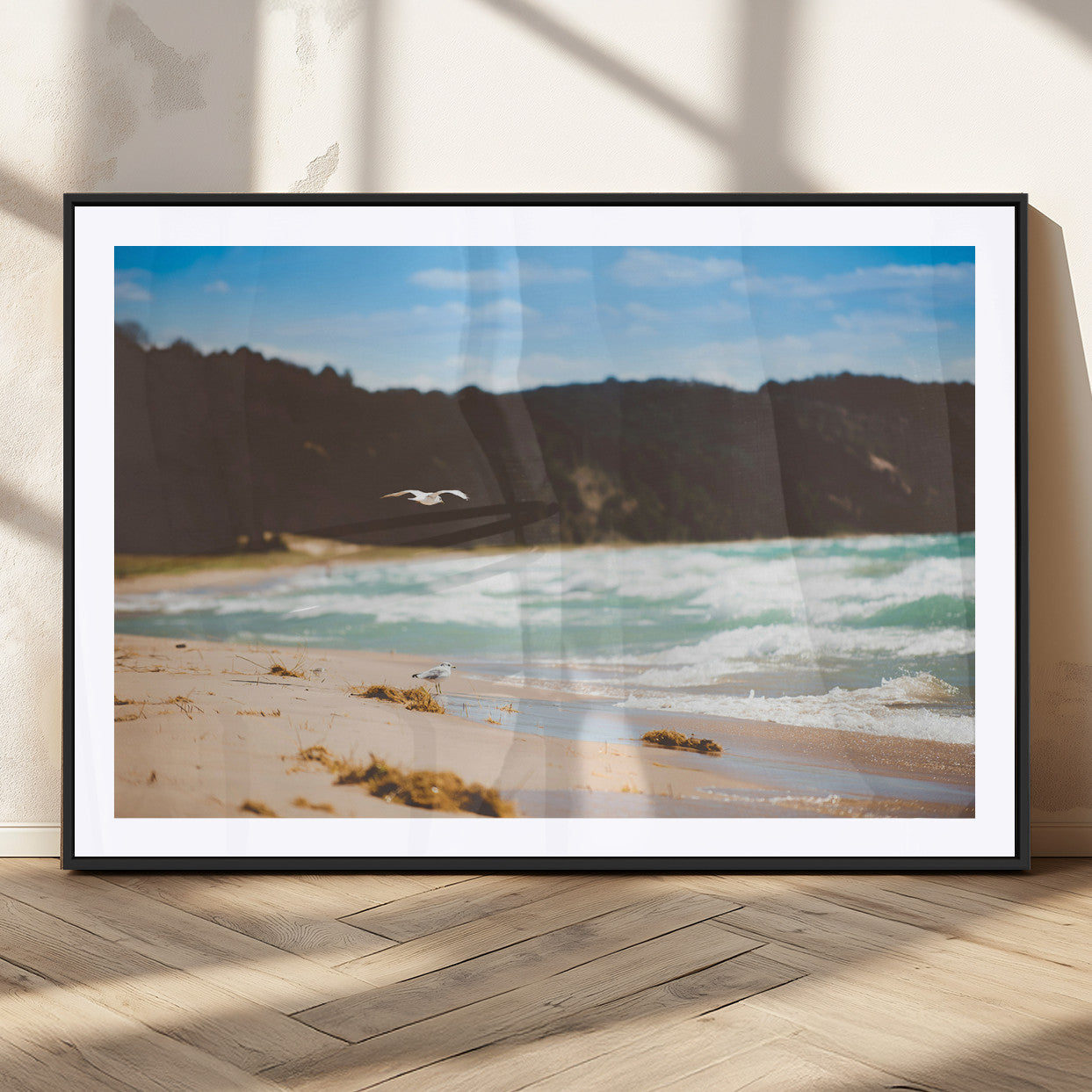 Serene beach scene with gentle ocean waves, sandy shore, and a seagull flying under a blue sky, perfect for coastal and nature-inspired decor.