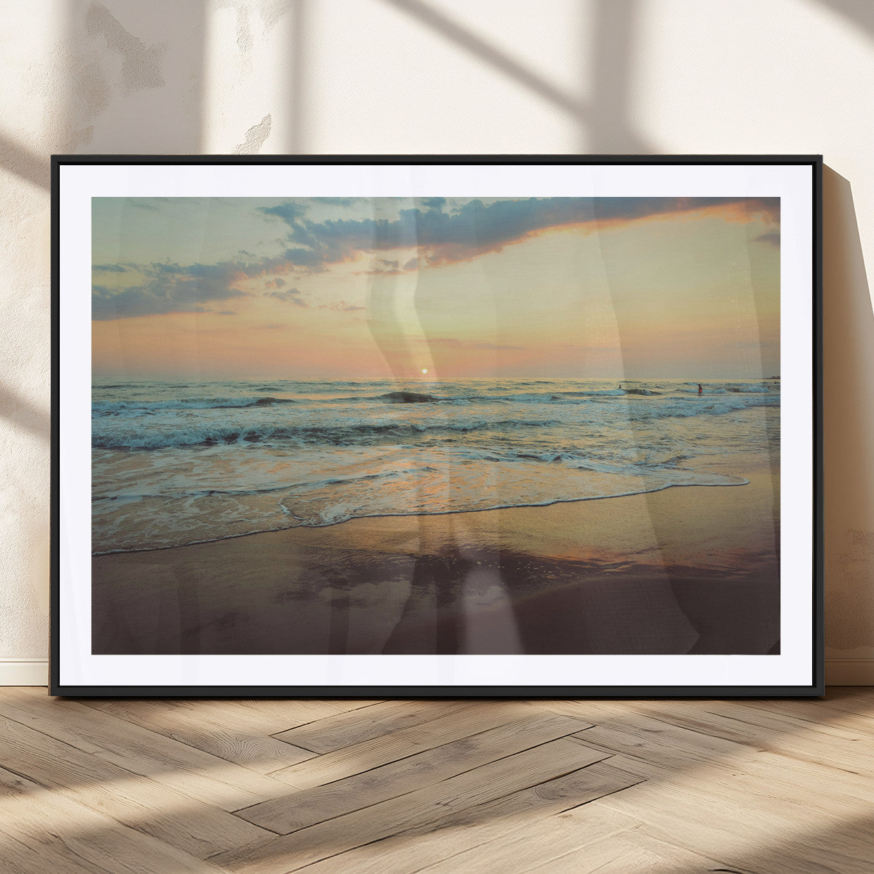 Warm sunset over gentle ocean waves with pastel sky and reflections on wet sand, creating a calm and soothing beach ambiance.