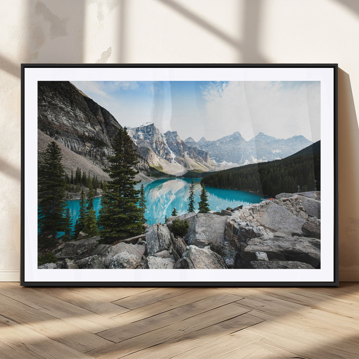 Stunning view of Moraine Lake with turquoise waters reflecting snow-capped mountains and evergreen trees, creating a peaceful alpine decor.