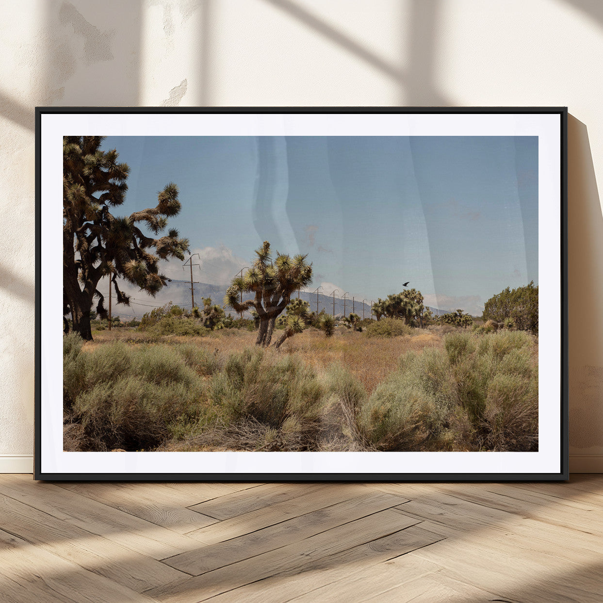 Scenic desert landscape with Joshua trees, dry grass, and distant mountains under a clear blue sky, perfect for southwestern and rustic decor.