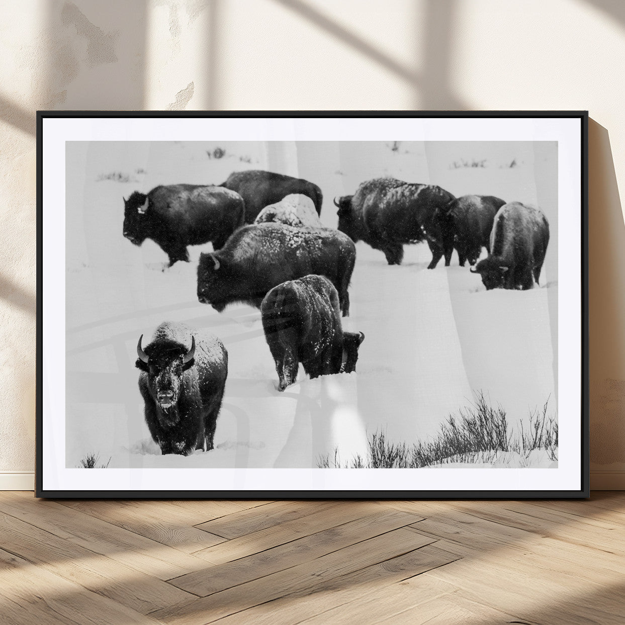 Black and white photograph of a bison herd in a snowy landscape, with snow-covered fur and a rugged wilderness setting, perfect for rustic lodge decor.