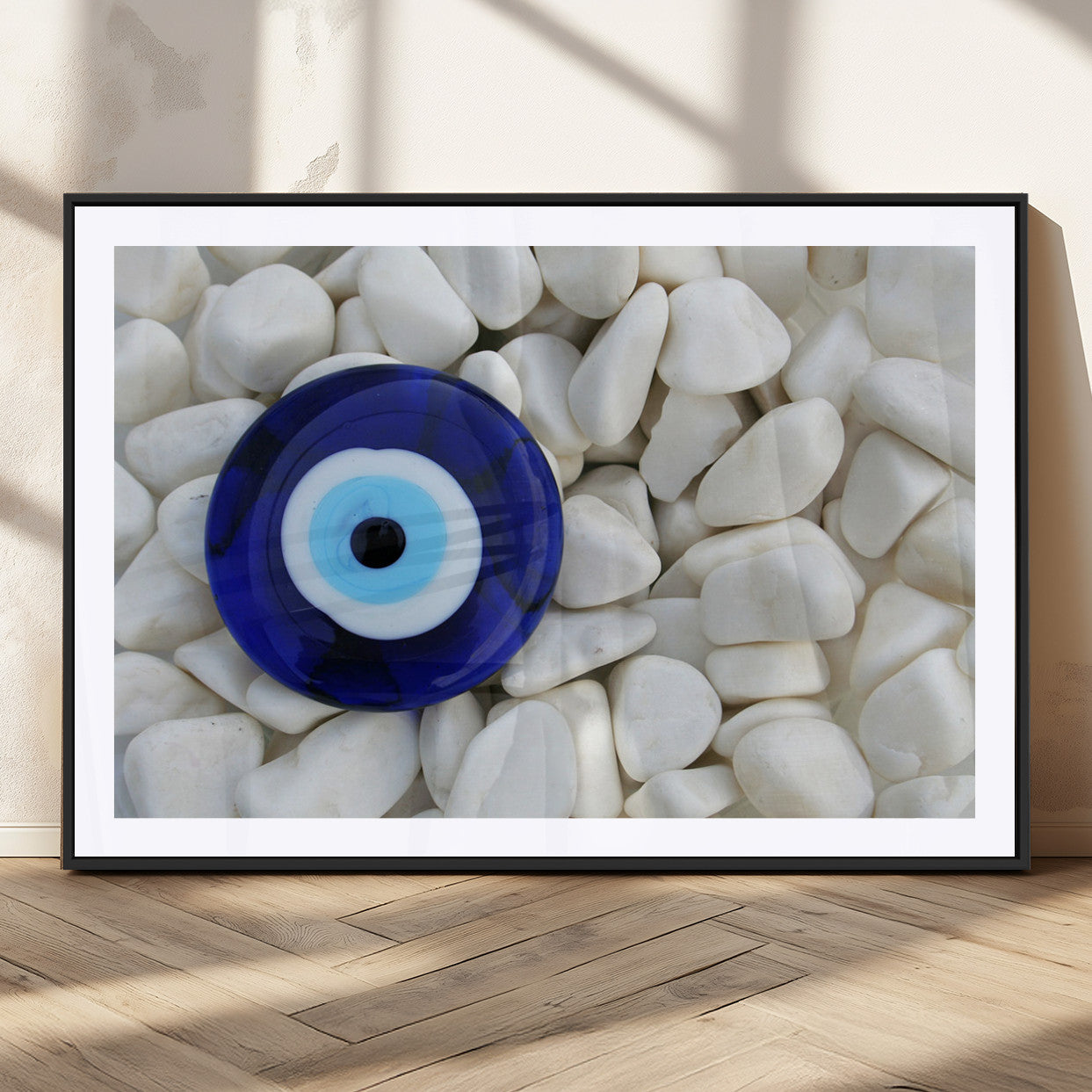 A close-up of a blue evil eye charm placed on white pebbles, symbolizing protection and good luck.