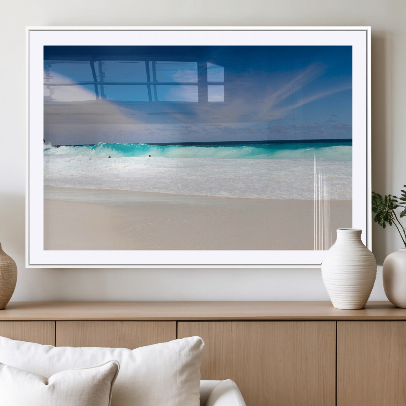 Turquoise waves crash onto a pristine white sand beach under a vivid blue sky with wispy clouds, creating a peaceful and refreshing coastal scene.