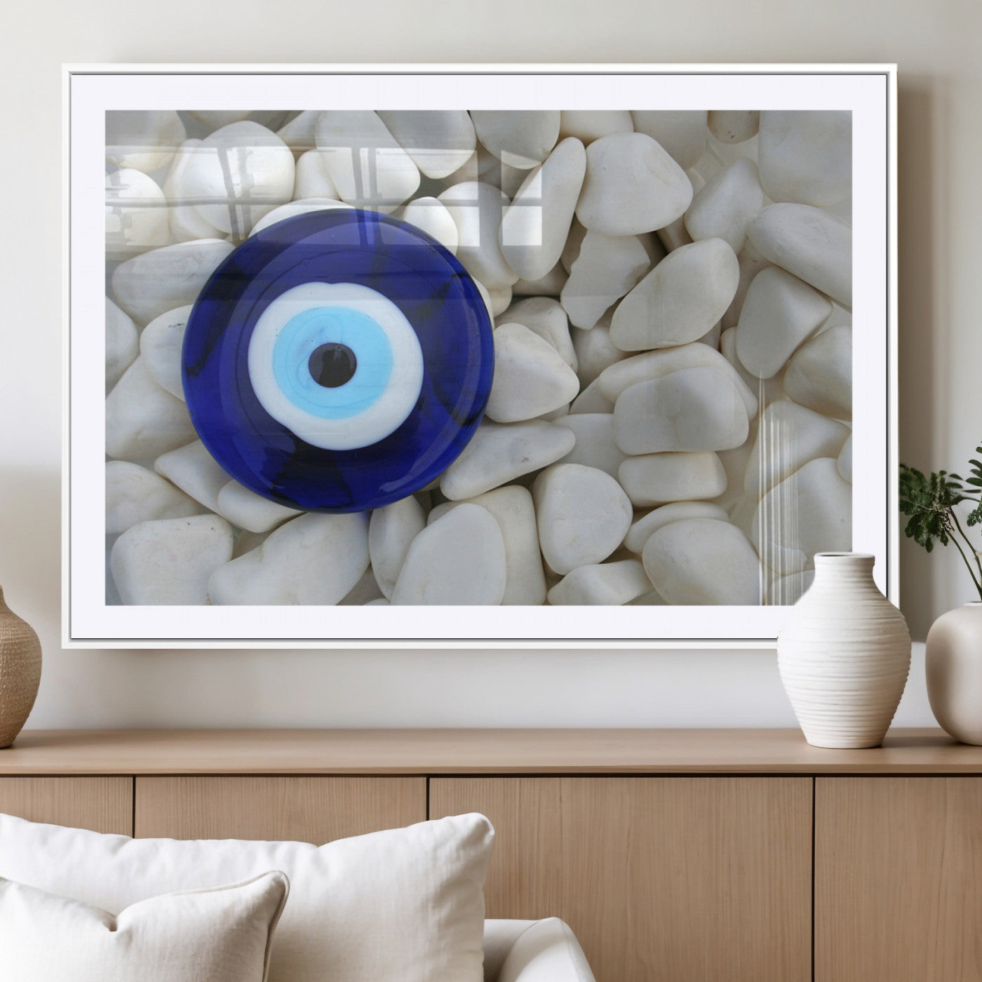 A close-up of a blue evil eye charm placed on white pebbles, symbolizing protection and good luck.