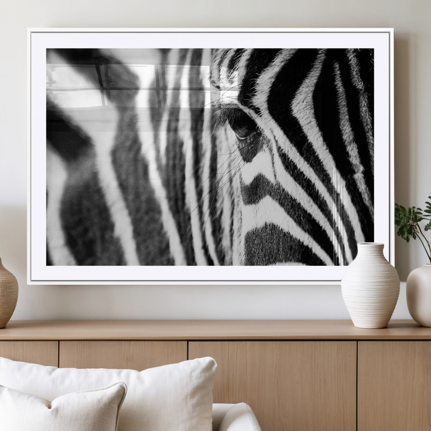 A close-up black and white photograph of a zebra's eye, showcasing the intricate patterns of its stripes in sharp detail.