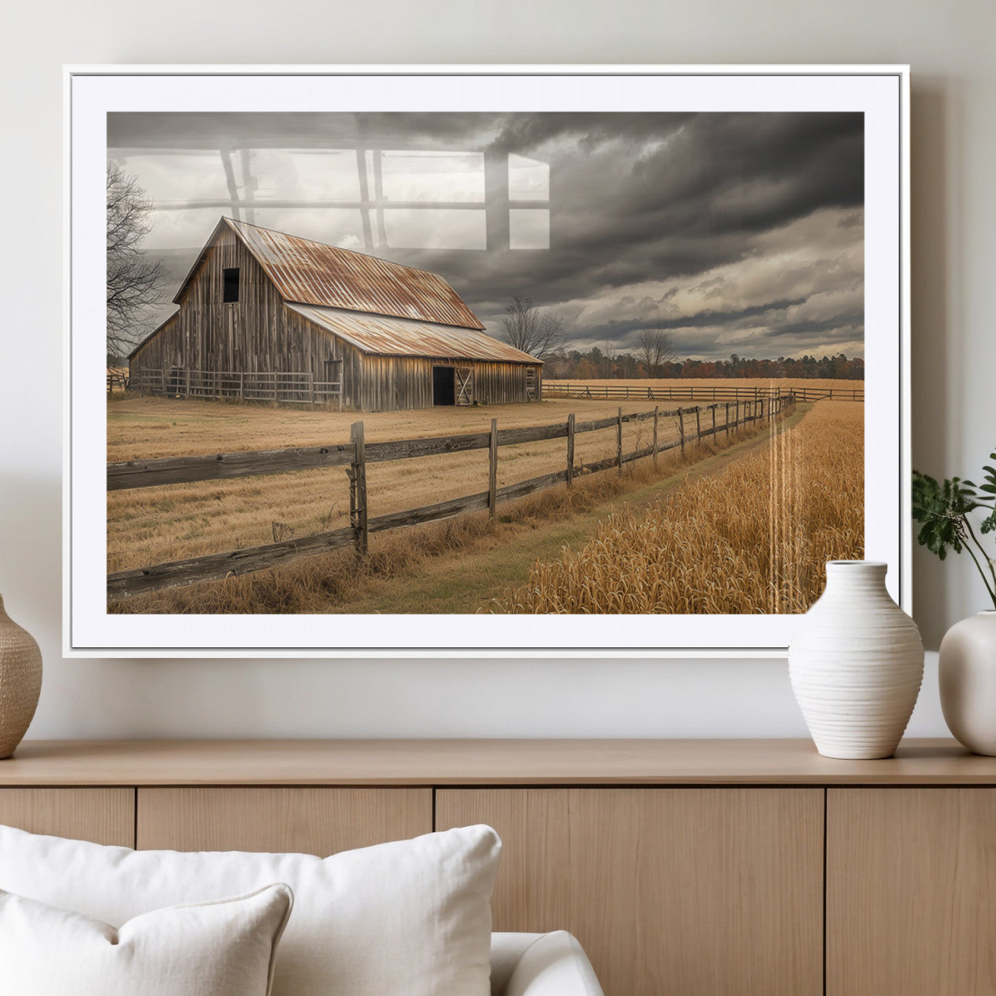"Rustic barn with a weathered metal roof, surrounded by a wooden fence and golden fields under an overcast sky with dramatic clouds."