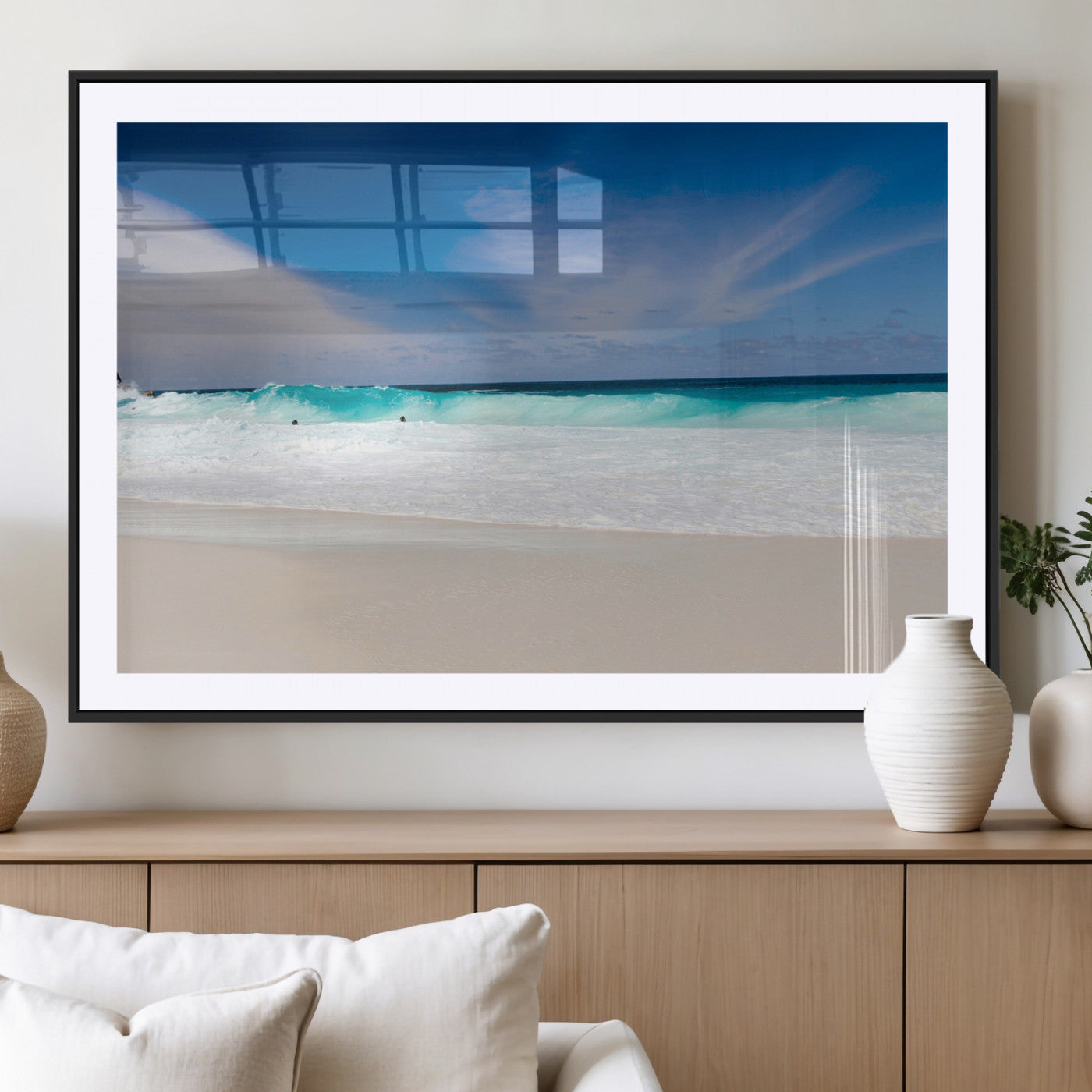 Turquoise waves crash onto a pristine white sand beach under a vivid blue sky with wispy clouds, creating a peaceful and refreshing coastal scene.