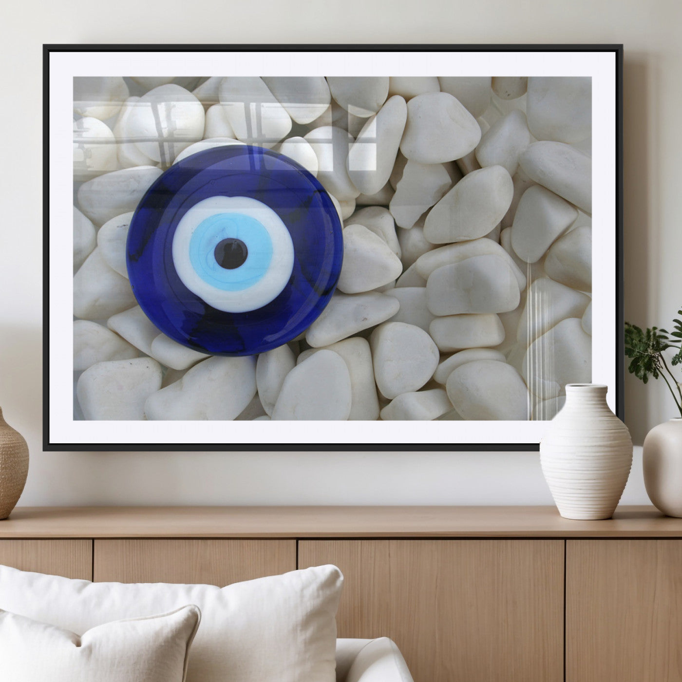 A close-up of a blue evil eye charm placed on white pebbles, symbolizing protection and good luck.