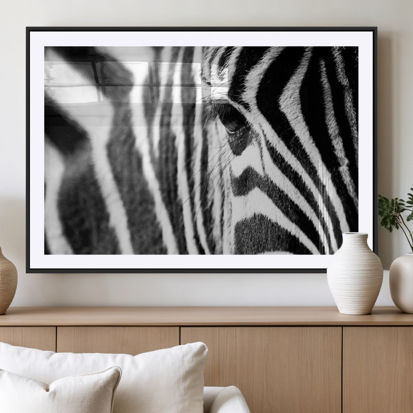 A close-up black and white photograph of a zebra's eye, showcasing the intricate patterns of its stripes in sharp detail.