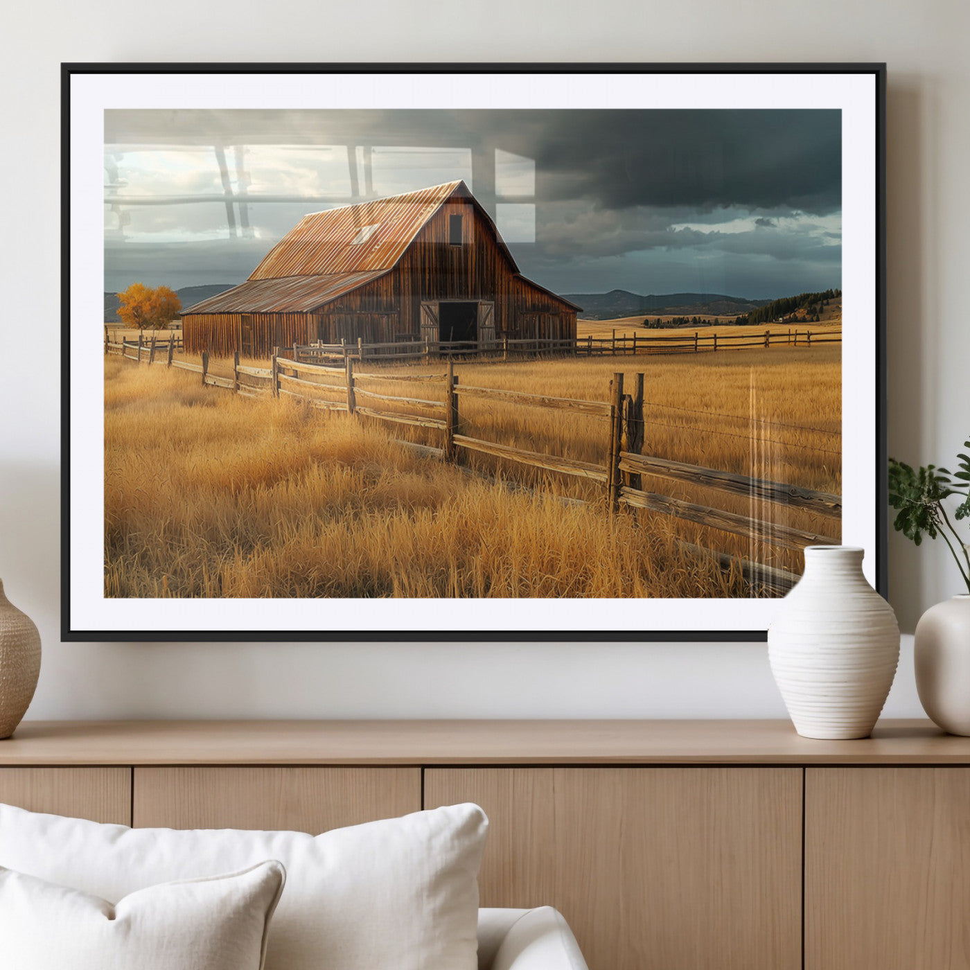 "Golden fields surrounding a rustic barn with a weathered roof, a wooden fence, and dramatic skies with sunlight breaking through the clouds."